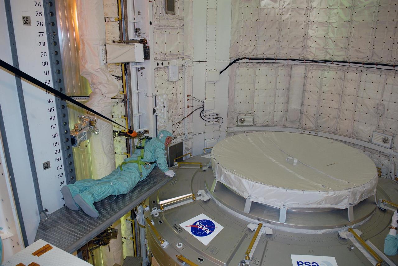 KENNEDY SPACE CENTER, FLA. -- In space shuttle Discovery's payload bay, STS-120 crew members get a close look at the equipment and payloads.  Seen here stretched out on a platform next to the Italian-built U.S. Node 2, named Harmony, is Mission Specialist Paolo Nespoli, who represents the European Space Agency.  The TCDT provides astronauts and ground crews an opportunity to participate in various simulated countdown activities, including equipment familiarization and emergency training. The STS-120 mission will deliver the U.S. Node 2 module, named Harmony, aboard space shuttle Discovery to the International Space Station.  Launch of Discovery on mission STS-120 is targeted for Oct. 23 at 11:38 a.m. EDT on a 14-day mission.  Photo credit: NASA/Kim Shiflett