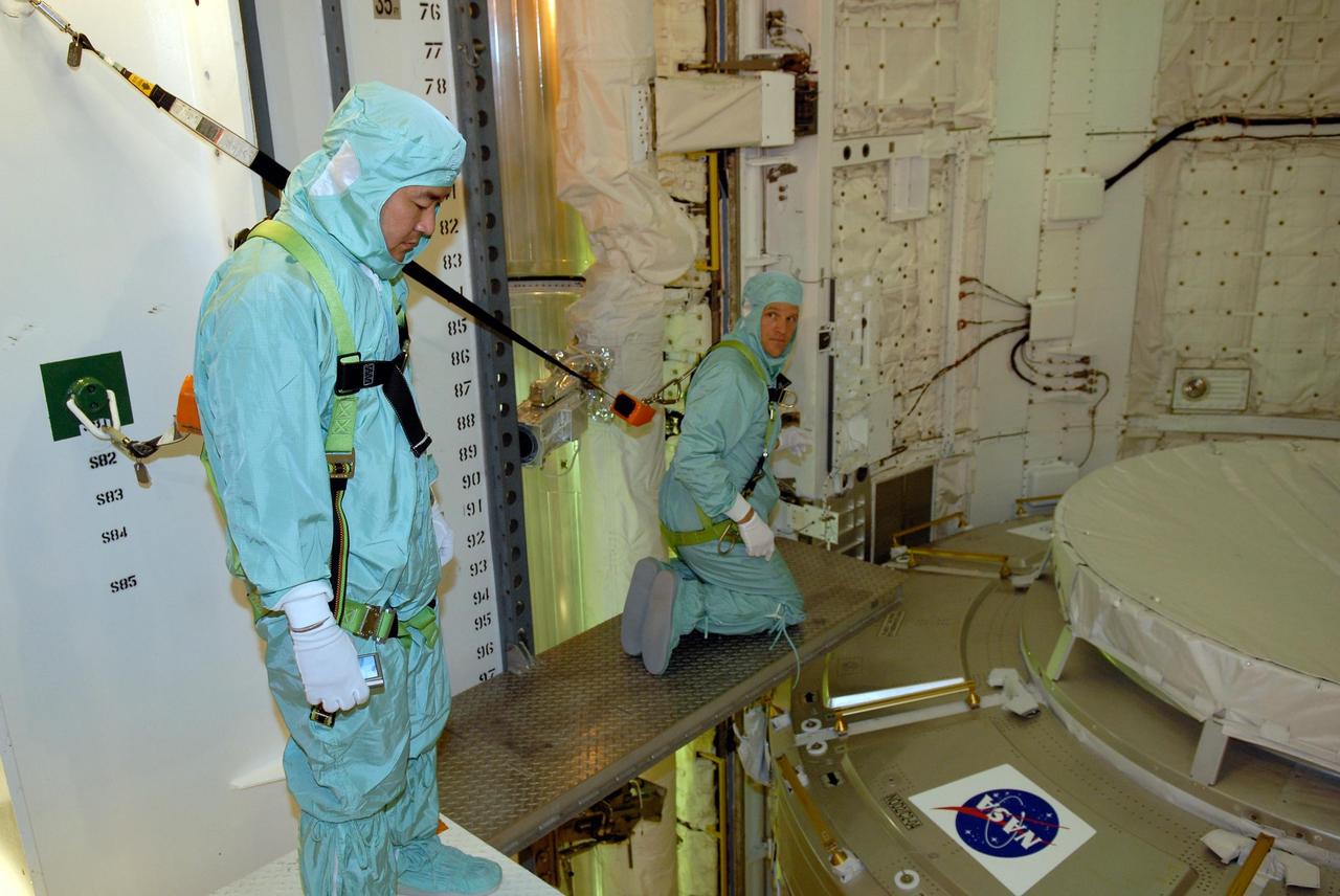 KENNEDY SPACE CENTER, FLA. -- In space shuttle Discovery's payload bay, STS-120 crew members get a close look at the equipment and payloads.  Seen here are Mission Specialists Daniel Tani (left) and Scott Parazynski, looking over the Italian-built U.S. Node 2, named Harmony.  The TCDT provides astronauts and ground crews an opportunity to participate in various simulated countdown activities, including equipment familiarization and emergency training. The STS-120 mission will deliver the U.S. Node 2 module, named Harmony, aboard space shuttle Discovery to the International Space Station.  Launch of Discovery on mission STS-120 is targeted for Oct. 23 at 11:38 a.m. EDT on a 14-day mission.  Photo credit: NASA/Kim Shiflett