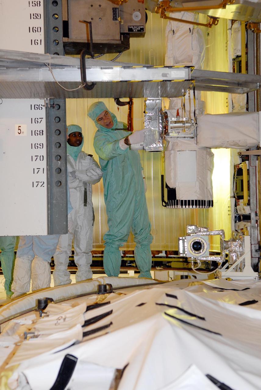 KENNEDY SPACE CENTER, FLA. -- In space shuttle Discovery's payload bay, STS-120 crew members get a close look at the equipment and payloads.  Seen here are Mission Specialists Stephanie Wilson and Paolo Nespoli, who represents the European Space Agency.  The TCDT provides astronauts and ground crews an opportunity to participate in various simulated countdown activities, including equipment familiarization and emergency training. The STS-120 mission will deliver the U.S. Node 2 module, named Harmony, aboard space shuttle Discovery to the International Space Station.  Launch of Discovery on mission STS-120 is targeted for Oct. 23 at 11:38 a.m. EDT on a 14-day mission.  Photo credit: NASA/Kim Shiflett