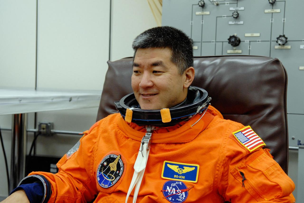 KENNEDY SPACE CENTER, FLA. -- STS-120 Mission Specialist Daniel Tani is putting on his launch and entry suit for a simulated launch countdown, part of the prelaunch terminal countdown demonstration test, or TCDT. His name patch reflects the nicknames the crew gave each other for the event. The TCDT provides astronauts and ground crews an opportunity to participate in various launch preparation activities, including equipment familiarization,  emergency training and the simulated countdown. The STS-120 mission will deliver the U.S. Node 2 module, named Harmony, aboard space shuttle Discovery to the International Space Station.  Launch of Discovery on mission STS-120 is targeted for Oct. 23 at 11:38 a.m. EDT on a 14-day mission. Photo credit: NASA/Kim Shiflett