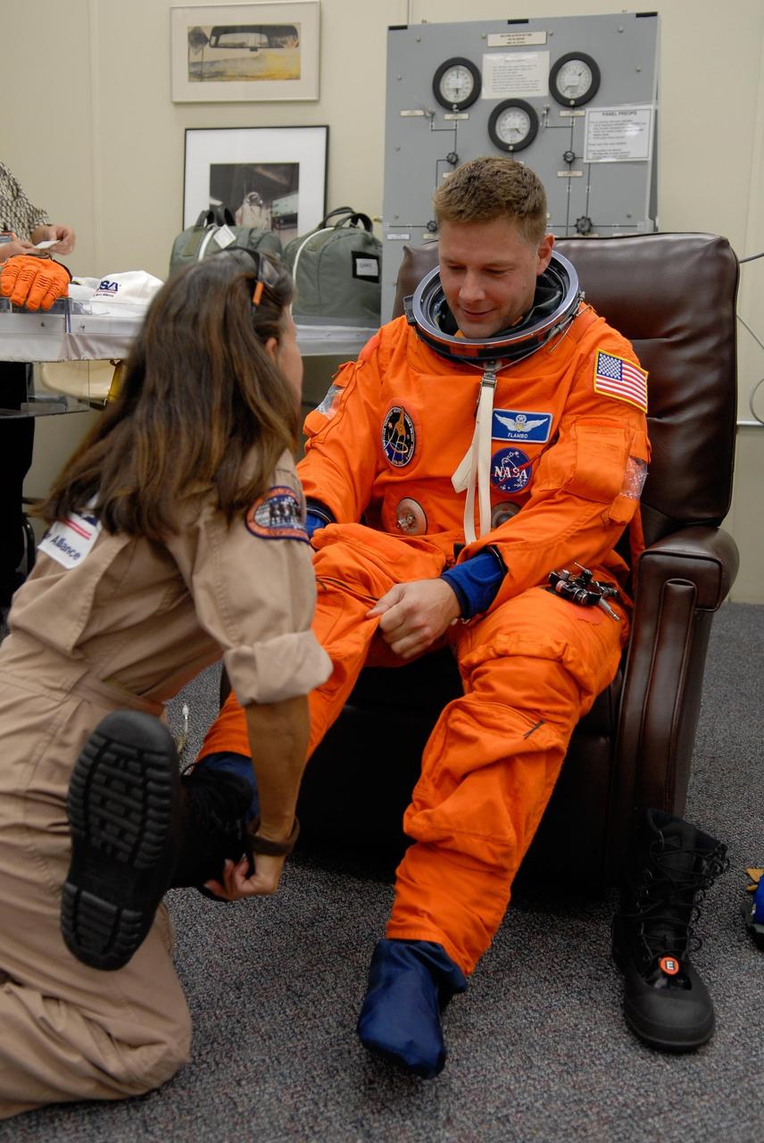 KENNEDY SPACE CENTER, FLA. -- STS-120 Mission Specialist Doug Wheelock gets help with his boot as he suits up for a simulated launch countdown, part of the prelaunch terminal countdown demonstration test, or TCDT. His name patch reflects the nicknames the crew gave each other for the event. The TCDT provides astronauts and ground crews an opportunity to participate in various launch preparation activities, including equipment familiarization,  emergency training and the simulated countdown. The STS-120 mission will deliver the U.S. Node 2 module, named Harmony, aboard space shuttle Discovery to the International Space Station.  Launch of Discovery on mission STS-120 is targeted for Oct. 23 at 11:38 a.m. EDT on a 14-day mission. Photo credit: NASA/Kim Shiflett