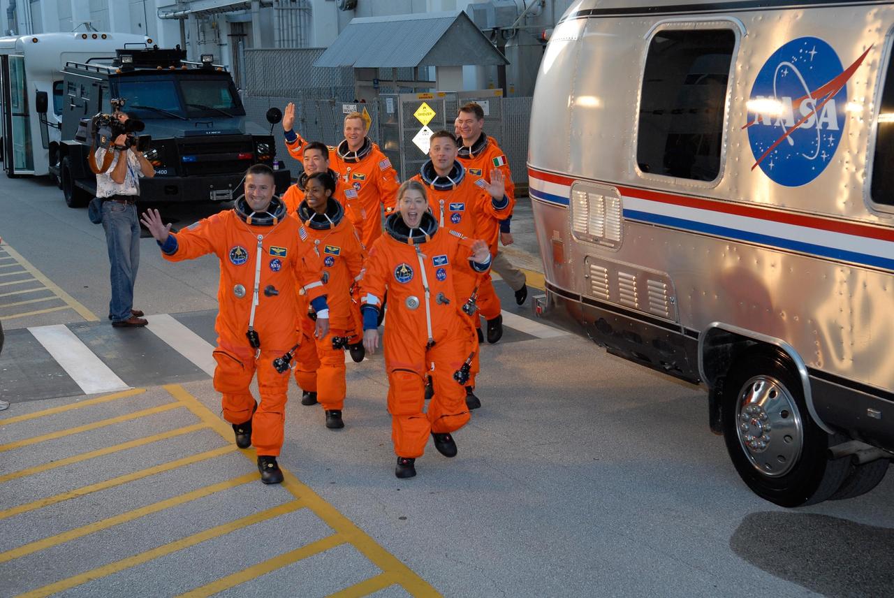 KENNEDY SPACE CENTER, FLA. -- At the Operations and Checkout Building, the crew members of space shuttle mission STS-120 prepare to board the bus that will transport them to Launch Pad 39A during their terminal countdown demonstration test activities. In the left row are, from front, Pilot George Zamka and Mission Specialists Stephanie Wilson, Daniel Tani, and Scott Parazynski. In the right row are, from front, Commander Pam Melroy and Mission Specialists Doug Wheelock and Paolo Nespoli. Nespoli represents the European Space Agency. After the mission, Tani will remain aboard the International Space Station and return with the STS-122 crew, targeted to launch Dec. 6. The terminal countdown demonstration test provides astronauts and ground crews an opportunity to participate in various simulated countdown activities, including equipment familiarization and emergency training. The STS-120 mission will deliver the U.S. Node 2 module, named Harmony, aboard space shuttle Discovery to the ISS. Discovery's launch is targeted for Oct. 23 at 11:38 a.m. EDT on a 14-day mission. Photo credit: NASA/Kim Shiflett