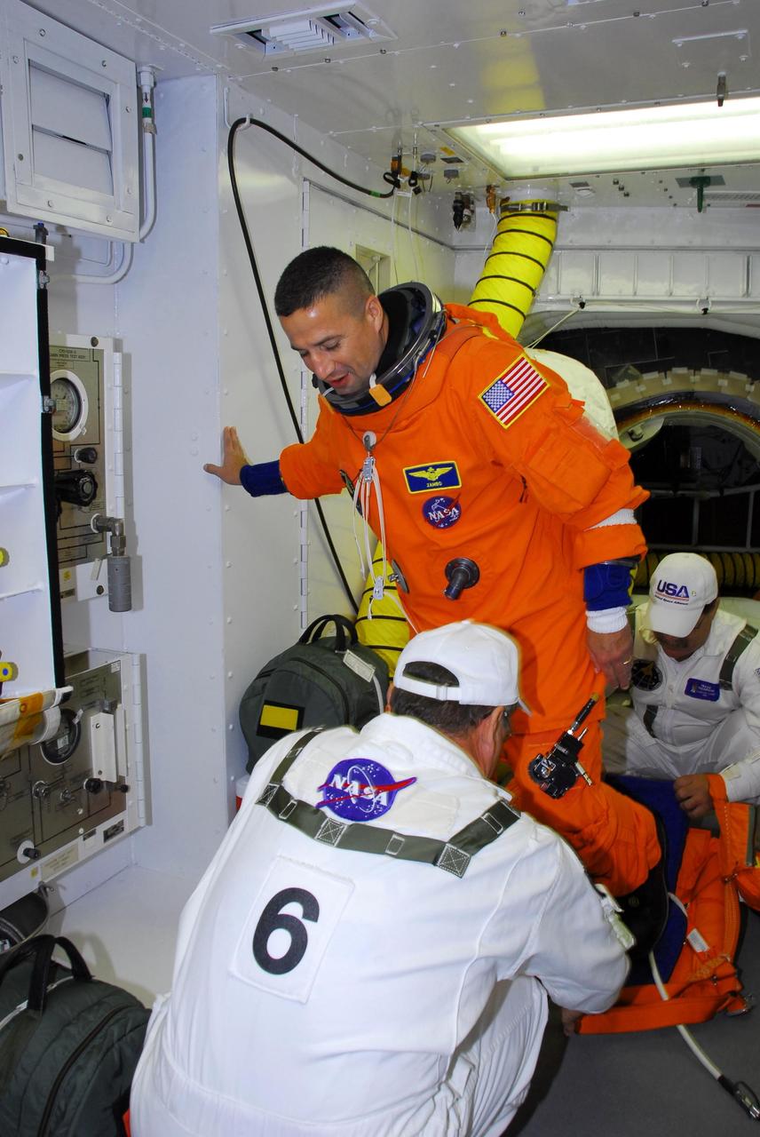 KENNEDY SPACE CENTER, FLA. -- In the white room on Launch Pad 39A, the closeout crew helps STS-120 Pilot George Zamka to get into a parachute pack before entering space shuttle Discovery for a simulated launch countdown.  The countdown is the culmination of the prelaunch terminal countdown demonstration test, or TCDT.  His name patch reflects the nicknames the crew gave each other for the event.  The TCDT at NASA's Kennedy Space Center provides astronauts and ground crews an opportunity to participate in various launch preparation activities, including equipment familiarization and  emergency training. The STS-120 mission will deliver the U.S. Node 2 module, named Harmony, aboard space shuttle Discovery to the International Space Station.  Discovery is targeted to launch on its 14-day mission at 11:38 a.m. EDT on Oct. 23. Photo credit: NASA/George Shelton