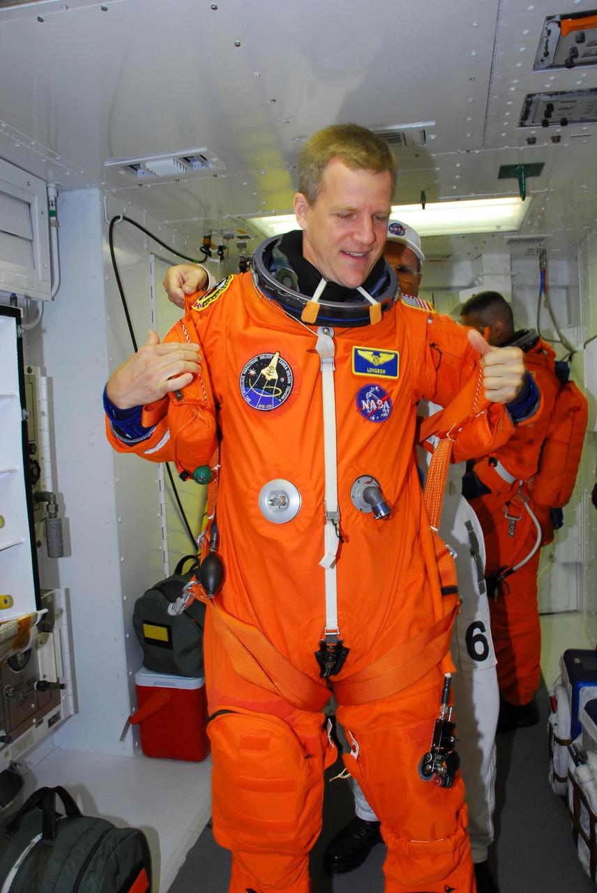 KENNEDY SPACE CENTER, FLA. -- In the white room on Launch Pad 39A, STS-120 Mission Specialist Scott Parazynski dons his parachute pack before entering space shuttle Discovery for a simulated launch countdown.  The countdown is the culmination of the prelaunch terminal countdown demonstration test, or TCDT. His name patch reflects the nicknames the crew gave each other for the event.  The TCDT at NASA's Kennedy Space Center provides astronauts and ground crews an opportunity to participate in various launch preparation activities, including equipment familiarization and  emergency training. The STS-120 mission will deliver the U.S. Node 2 module, named Harmony, aboard space shuttle Discovery to the International Space Station.  Discovery is targeted to launch on its 14-day mission at 11:38 a.m. EDT on Oct. 23. Photo credit: NASA/George Shelton