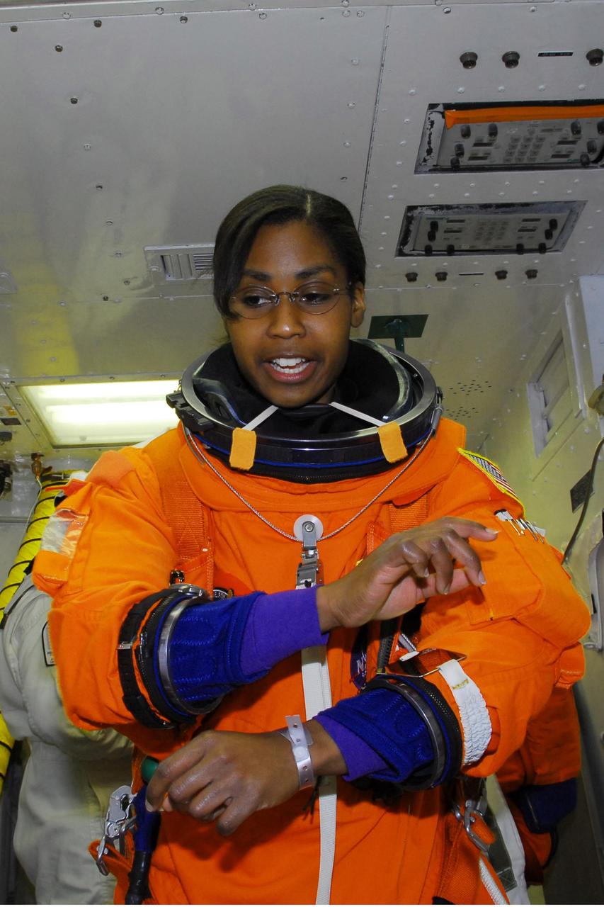 KENNEDY SPACE CENTER, FLA. -- In the white room on Launch Pad 39A, STS-120 Mission Specialist Stephanie Wilson adjusts her launch suit before entering space shuttle Discovery for a simulated launch countdown. The countdown is the culmination of the prelaunch terminal countdown demonstration test, or TCDT. The TCDT at NASA's Kennedy Space Center provides astronauts and ground crews an opportunity to participate in various launch preparation activities, including equipment familiarization and emergency training. The STS-120 mission will deliver the U.S. Node 2 module, named Harmony, aboard space shuttle Discovery to the International Space Station. Discovery is targeted to launch on its 14-day mission at 11:38 a.m. EDT on Oct. 23. Photo credit: NASA/George Shelton
