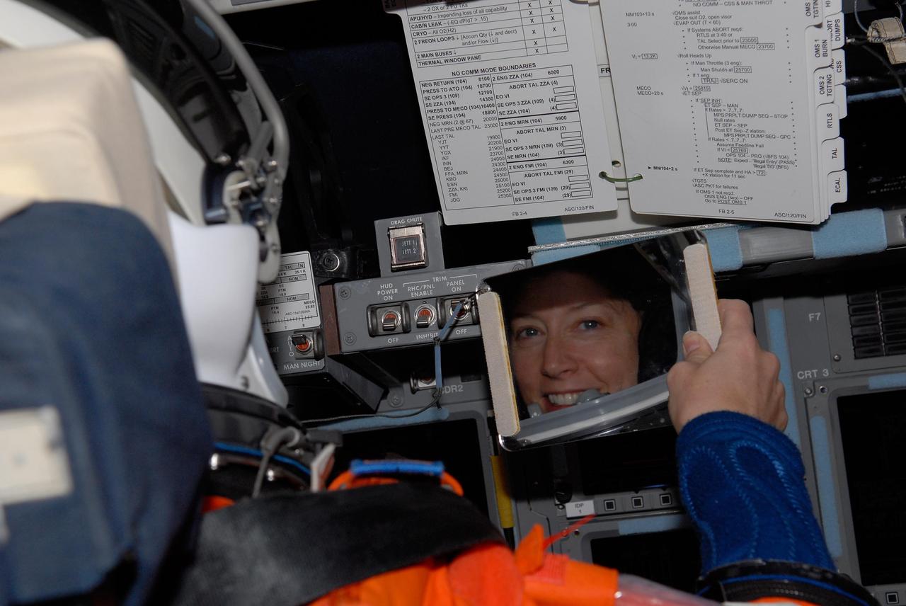 KENNEDY SPACE CENTER, FLA. -- Inside space shuttle Discovery, STS-120  Commander Pamela Melroy's reflection shows her happiness taking part in a simulated launch countdown, culmination of the prelaunch terminal countdown demonstration test, or TCDT. The TCDT at NASA's Kennedy Space Center provides astronauts and ground crews an opportunity to participate in various launch preparation activities, including equipment familiarization and emergency training. The STS-120 mission will deliver the U.S. Node 2 module, named Harmony, aboard space shuttle Discovery to the International Space Station.  Discovery is targeted to launch on its 14-day mission at 11:38 a.m. EDT on Oct. 23. Photo credit: NASA/Kim Shiflett