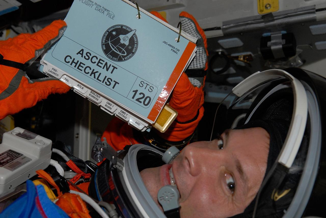 KENNEDY SPACE CENTER, FLA. -- Inside space shuttle Discovery, STS-120 Mission Specialist Doug Wheelock is ready with his checklist for the simulated launch countdown, culmination of the prelaunch terminal countdown demonstration test, or TCDT.  The TCDT at NASA's Kennedy Space Center provides astronauts and ground crews an opportunity to participate in various launch preparation activities, including equipment familiarization and emergency training. The STS-120 mission will deliver the U.S. Node 2 module, named Harmony, aboard space shuttle Discovery to the International Space Station.  Discovery is targeted to launch on its 14-day mission at 11:38 a.m. EDT on Oct. 23. Photo credit: NASA/Kim Shiflett