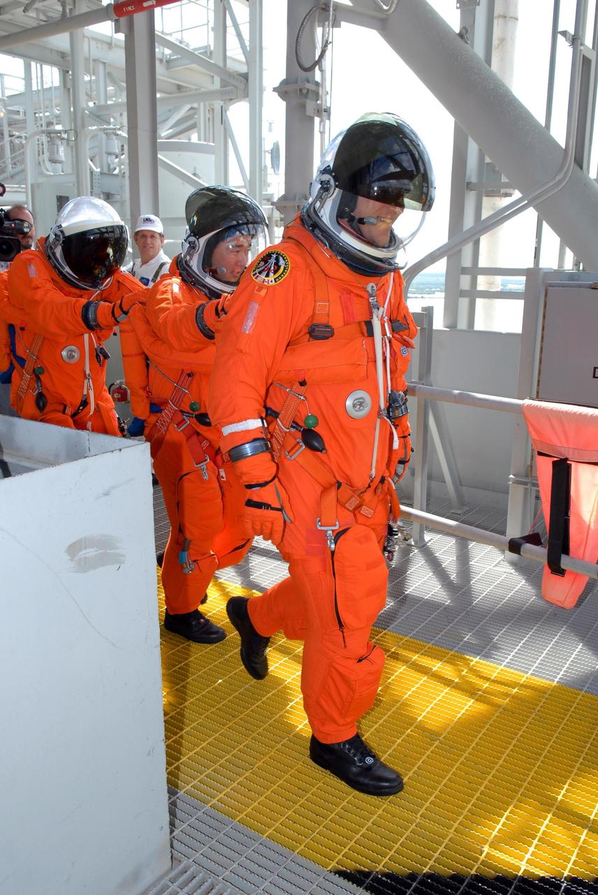 KENNEDY SPACE CENTER, FLA. -- STS-120 crew members practice emergency egress from Launch Pad 39A after completing a simulated launch countdown, culmination of the prelaunch terminal countdown demonstration test, or TCDT.  Leading the way to the slidewire baskets is Mission Specialist Scott Parazynski, with Mission Specialist Daniel Tani and others behind him.  The TCDT at NASA's Kennedy Space Center provides astronauts and ground crews an opportunity to participate in various launch preparation activities, including equipment familiarization and emergency training. The STS-120 mission will deliver the U.S. Node 2 module, named Harmony, aboard space shuttle Discovery to the International Space Station.  Discovery is targeted to launch on its 14-day mission at 11:38 a.m. EDT on Oct. 23. Photo credit: NASA/Kim Shiflett