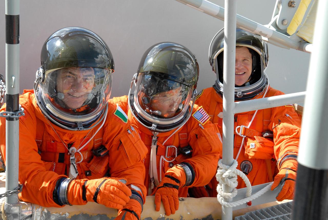 KENNEDY SPACE CENTER, FLA. -- During emergency egress from Launch Pad 39A, STS-120 Mission Specialists relax inside the slidewire basket.  From left are Mission Specialists Paolo Nespoli, Daniel Tani and Scott Parazynski. The basket can carry them to a safe landing site below, if needed. The activity is part of the prelaunch terminal countdown demonstration test, or TCDT.  The TCDT at NASA's Kennedy Space Center provides astronauts and ground crews an opportunity to participate in various launch preparation activities, including equipment familiarization and emergency training. The STS-120 mission will deliver the U.S. Node 2 module, named Harmony, aboard space shuttle Discovery to the International Space Station.  Discovery is targeted to launch on its 14-day mission at 11:38 a.m. EDT on Oct. 23. Photo credit: NASA/Kim Shiflett