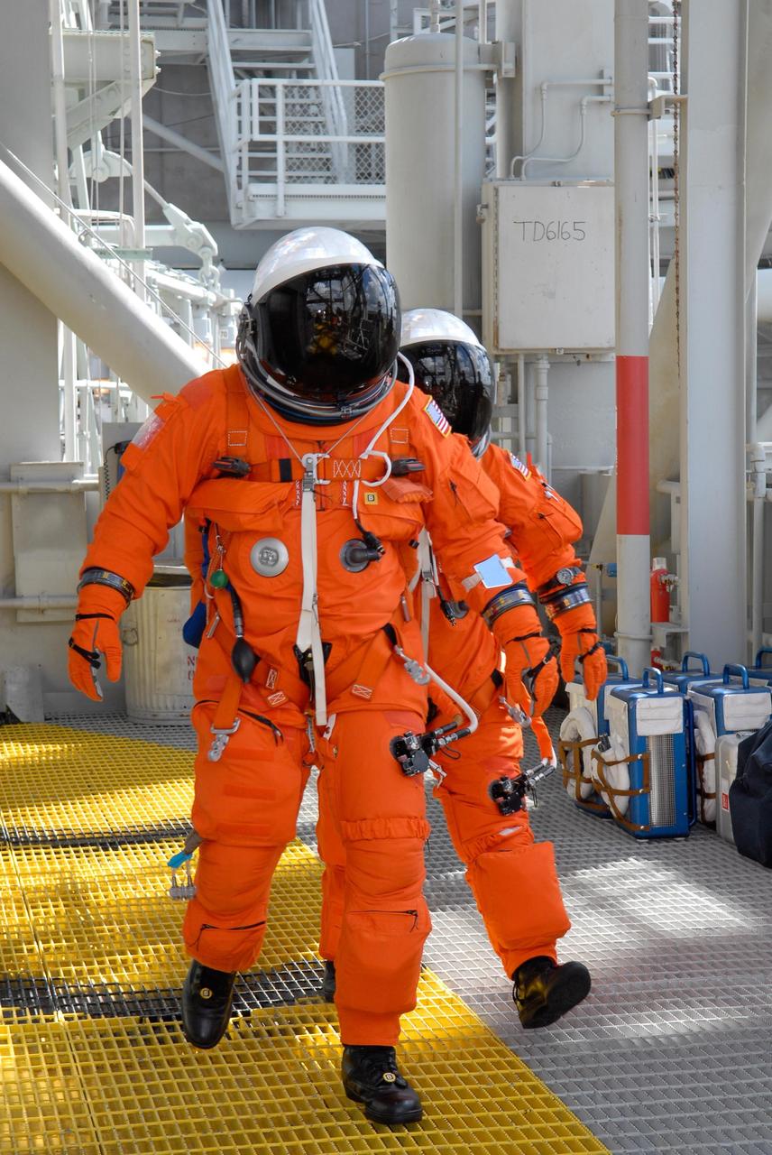 KENNEDY SPACE CENTER, FLA. -- During emergency egress from Launch Pad 39A, STS-120 Pilot George Zamka and Commander Pamela Melroy head for the slidewire baskets.  The basket can carry them to a safe landing site below, if needed. The activity is part of the prelaunch terminal countdown demonstration test, or TCDT.  The TCDT at NASA's Kennedy Space Center provides astronauts and ground crews an opportunity to participate in various launch preparation activities, including equipment familiarization and emergency training. The STS-120 mission will deliver the U.S. Node 2 module, named Harmony, aboard space shuttle Discovery to the International Space Station.  Discovery is targeted to launch on its 14-day mission at 11:38 a.m. EDT on Oct. 23. Photo credit: NASA/Kim Shiflett