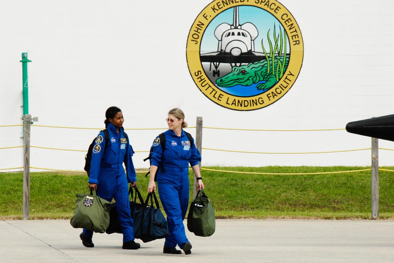 KENNEDY SPACE CENTER, FLA. -- The crew members of space shuttle mission STS-120 prepare for their return to NASA's Johnson Space Center in Houston following three days of terminal countdown demonstration test, or TCDT, activities.  At Kennedy Space Center's Shuttle Landing Facility, Mission Specialist Stephanie Wilson, at left, and Commander Pam Melroy are packed and ready to board their aircraft. Melroy is the second woman to command a shuttle mission.  The TCDT provides astronauts and ground crews with equipment familiarization, emergency egress training and a simulated launch countdown. The STS-120 mission will deliver the U.S. Node 2 module, named Harmony, aboard space shuttle Discovery to the International Space Station on a 14-day mission.  Discovery's launch is targeted for Oct. 23 at 11:38 a.m. EDT.  Photo credit: NASA/Kim Shiflett