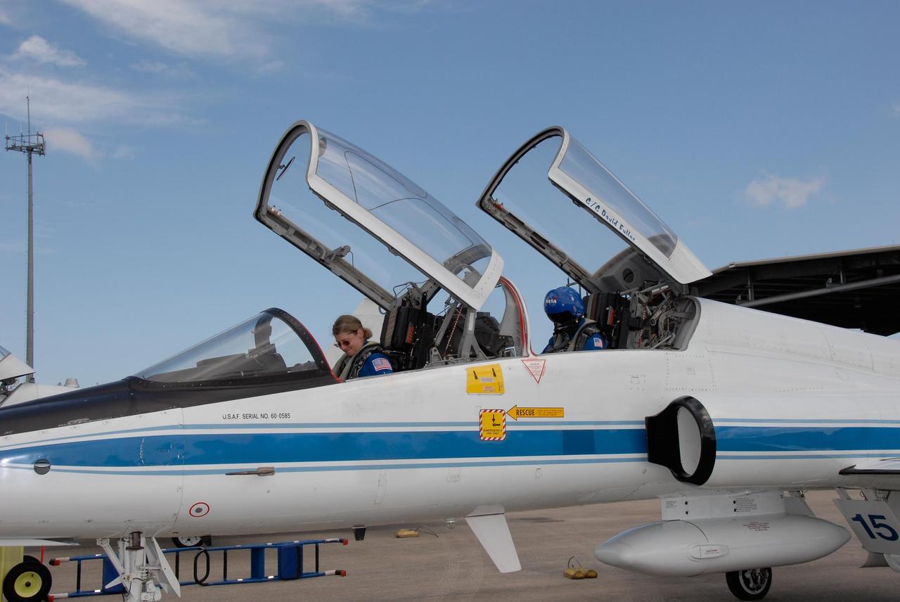 KENNEDY SPACE CENTER, FLA. -- The crew members of space shuttle mission STS-120 prepare for their return to NASA's Johnson Space Center in Houston following three days of terminal countdown demonstration test, or TCDT, activities.  At Kennedy Space Center's Shuttle Landing Facility, Commander Pam Melroy, in front, and Mission Specialist Stephanie Wilson secure themselves in a T-38 jet aircraft for takeoff. Melroy is the second woman to command a shuttle mission.  The TCDT provides astronauts and ground crews with equipment familiarization, emergency egress training and a simulated launch countdown. The STS-120 mission will deliver the U.S. Node 2 module, named Harmony, aboard space shuttle Discovery to the International Space Station on a 14-day mission.  Discovery's launch is targeted for Oct. 23 at 11:38 a.m. EDT.  Photo credit: NASA/Kim Shiflett