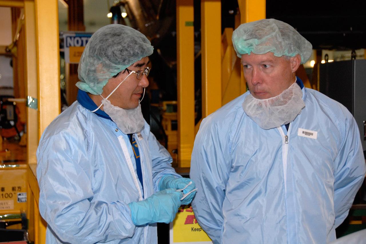 KENNEDY SPACE CENTER, FLA. -- In the Space Station Processing Facility at NASA's Kennedy Space Center, STS-123 Mission Specialist Takao Doi (left) and Commander Dominic Gorie confer about the mission payload, the Kibo Experiment Logistics Module Pressurized Section, they are looking over.  They are at the center for a crew equipment interface test, which allows familiarization with equipment they will use during the mission. Crew members are Commander Dominic Gorie, Pilot Gregory Johnson and Mission Specialists Richard Linnehan, Takao Doi, Robert Behnken, Gerrett Reisman and Michael Foreman.  Doi represents the Japan Aerospace Exploration Agency.  Reisman will remain on the space station after the mission as a flight engineer for Expedition 16. STS-123 will carry and install one of the components of the Japanese Experiment Module, or JEM.  Known as Kibo, the JEM comprises six components: two research facilities -- the Pressurized Module and Exposed Facility; a Logistics Module attached to each of them; a Remote Manipulator System; and an Inter-Orbit Communication System unit. The various components of JEM will be assembled in space over the course of three space shuttle missions. The first of those three missions, STS-123, will carry the Experiment Logistics Module Pressurized Section aboard the space shuttle Endeavour, targeted for launch in February 2008.  Photo credit:  NASA/Dimitrios Gerondidakis
