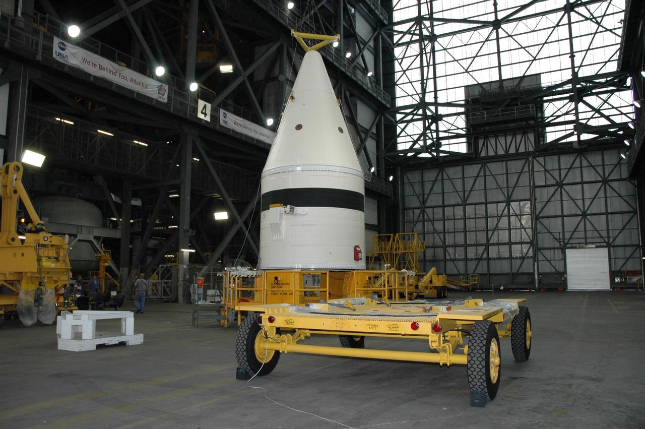 KENNEDY SPACE CENTER, FLA. -- In the Vehicle Assembly Building at NASA's Kennedy Space Center, the frustum is lowered onto a stand after being lifted from the transporter in the foreground.  The solid rocket booster segment will be added to the stack for space shuttle Atlantis, launch vehicle for mission STS-122 targeted for a December launch.  Atlantis will be carrying the Columbus Laboratory, Europe’s largest contribution to the construction of the International Space Station. It will support scientific and technological research in a microgravity environment. Columbus, a program of ESA, is a multifunctional, pressurized laboratory that will be permanently attached to Node 2 of the space station to carry out experiments in materials science, fluid physics and biosciences, as well as to perform a number of technological applications. Photo credit: NASA/Jack Pfaller