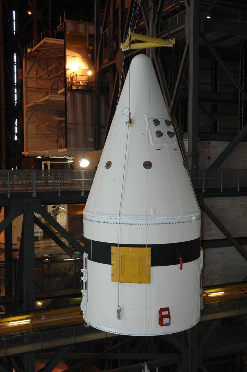 KENNEDY SPACE CENTER, FLA. -- In the Vehicle Assembly Building at NASA's Kennedy Space Center, a crane lifts a frustum towards platforms separating the transfer aisle from a high bay.   The solid rocket booster segment is being moved into a high bay where it will be added to the stack being prepared for space shuttle mission STS-122, targeted for launch in December. On this mission, Atlantis will carry the Columbus Laboratory, the European Space Agency's largest contribution to the International Space Station.  Columbus is a multifunctional, pressurized laboratory that will be permanently attached to U.S. Node 2, also called Harmony, to carry out experiments in materials science, fluid physics and biosciences, as well as to support a number of technological applications. Photo credit: NASA/Jack Pfaller