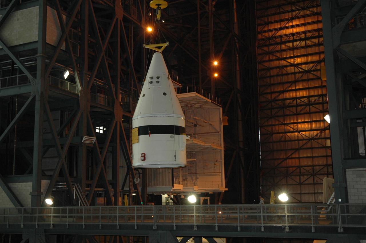 KENNEDY SPACE CENTER, FLA. -- In the Vehicle Assembly Building at NASA's Kennedy Space Center, a crane lifts a frustum over platforms into a high bay.   The solid rocket booster segment is being moved into a high bay where it will be added to the stack being prepared for space shuttle mission STS-122, targeted for launch in December. On this mission, Atlantis will carry the Columbus Laboratory, the European Space Agency's largest contribution to the International Space Station.  Columbus is a multifunctional, pressurized laboratory that will be permanently attached to U.S. Node 2, also called Harmony, to carry out experiments in materials science, fluid physics and biosciences, as well as to support a number of technological applications. Photo credit: NASA/Jack Pfaller