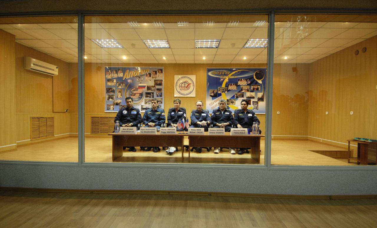 Baikonur, Kazakhstan -- Expedition 16 Commander Peggy Whitson, Flight Engineer and Soyuz Commander Yuri Malenchenko and Malaysian Spaceflight Participant Sheikh Muszaphar Shukor are protected behind glass during the State Commission meeting and press conference Oct. 9, 2007, at the Baikonur Cosmodrome in Kazakhstan. The crew is in preparation for their launch to the International Space Station Oct. 10 in their Soyuz TMA-11 spacecraft. Whitson and Malenchenko will spend six months on the station while Shukor will return to Earth Oct. 21 with two of the Expedition 15 crewmembers currently on the complex.  Photo credit: NASA/Bill Ingalls