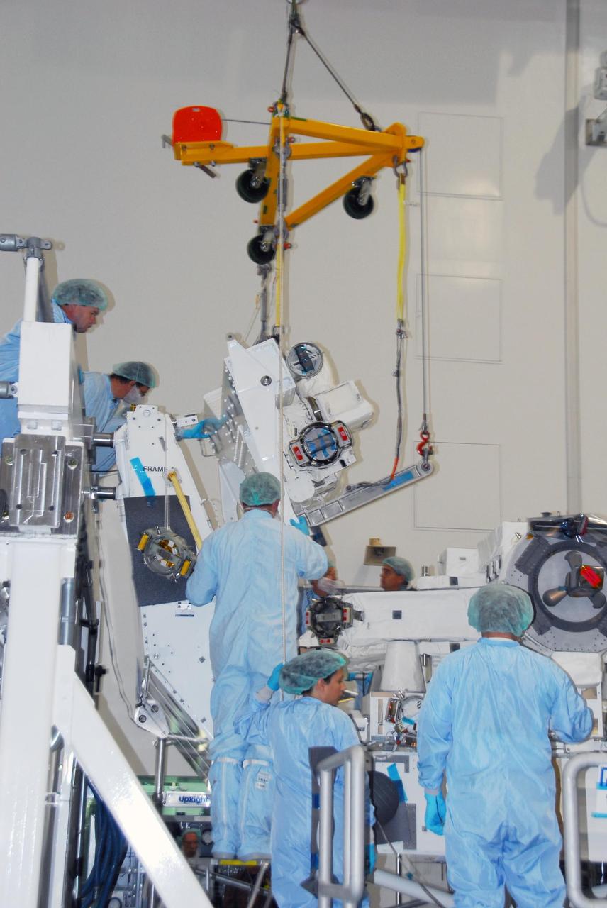 KENNEDY SPACE CENTER, FLA. -- In the Space Station Processing Facility at NASA's Kennedy Space Center, technicians aid with the lowering of the starboard arm of the Special Purpose Dexterous Manipulator, known as Dextre, toward the base. The arm will be installed on the base. Dextre is a sophisticated dual-armed robot, which is part of Canada's contribution to the International Space Station (ISS). Along with Canadarm2, whose technical name is the Space Station Remote Manipulator System, and a moveable work platform called the Mobile Base System, these three elements form a robotic system called the Mobile Servicing System, or MSS. The three components have been designed to work together or independently. Dextre is part of the payload scheduled on mission STS-123, targeted to launch Feb. 14. Photo credit: NASA/George Shelton