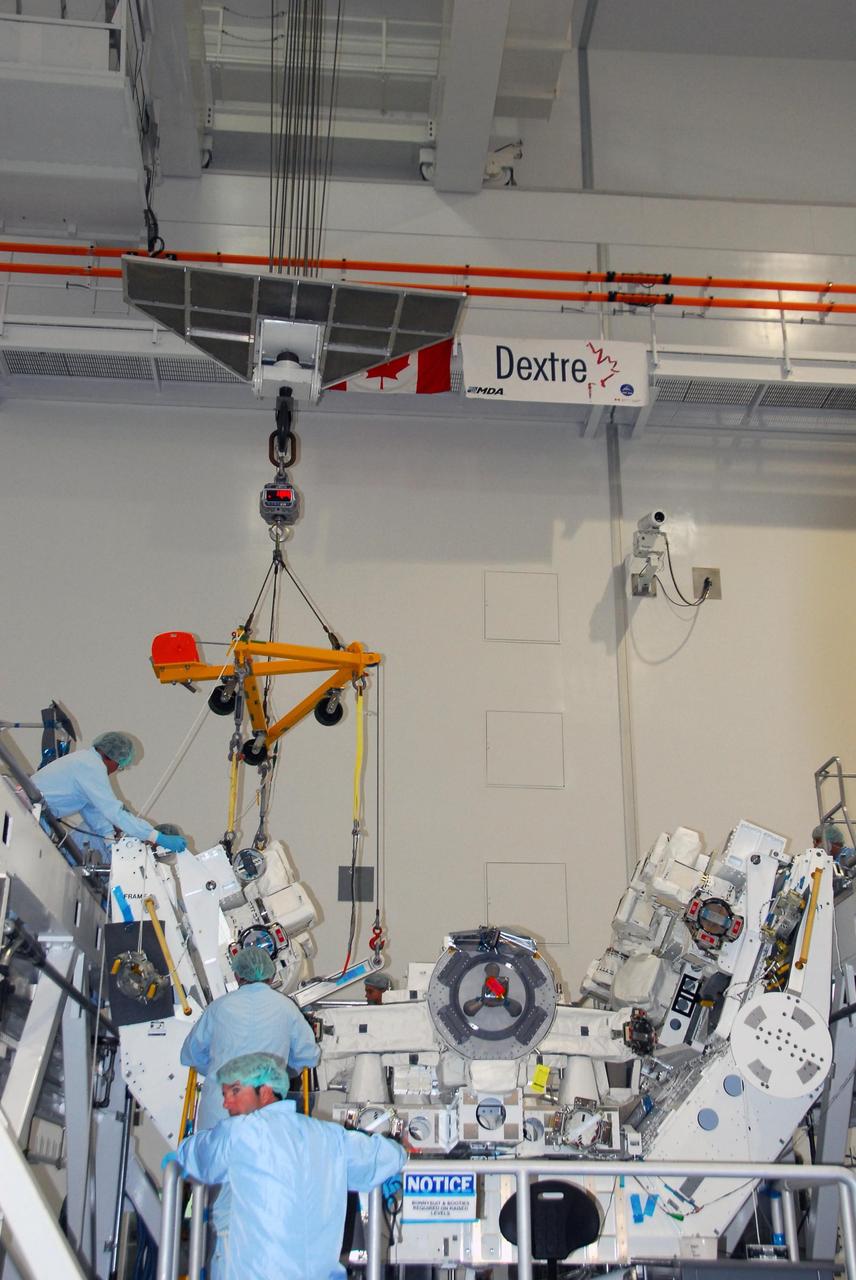 KENNEDY SPACE CENTER, FLA. -- In the Space Station Processing Facility at NASA's Kennedy Space Center, technicians help guide the starboard arm of the Special Purpose Dexterous Manipulator, known as Dextre, into place for installation on the base. Dextre is a sophisticated dual-armed robot, which is part of Canada's contribution to the International Space Station (ISS). Along with Canadarm2, whose technical name is the Space Station Remote Manipulator System, and a moveable work platform called the Mobile Base System, these three elements form a robotic system called the Mobile Servicing System, or MSS. The three components have been designed to work together or independently. Dextre is part of the payload scheduled on mission STS-123, targeted to launch Feb. 14. Photo credit: NASA/George Shelton