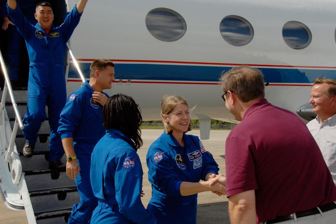 KENNEDY SPACE CENTER, FLA. --  STS-120 Commander Pamela Melroy is greeted by Mike Wetmore, director of Launch Vehicle Processing, as she exits the Shuttle Training Aircraft with the crew at NASA's Kennedy Space Center.  Melroy will be making her third shuttle flight, the second woman to command a shuttle mission.  Next to her is Mission Specialist Stephanie Wilson.  Behind them on the steps are Mission Specialists Doug Wheelock and Dan Tani (at top), who will be remaining behind to join the Expedition 16 crew after the mission is complete. At right is Shuttle Launch Director Mike Leinbach. The crew has returned to Kennedy to prepare for launch aboard space shuttle Discovery at 11:38 a.m. EDT on Oct. 23.  The mission will be the 23rd shuttle flight to the International Space Station, delivering the Italian-built U.S. Node 2, called Harmony.  The 14-day mission includes five spacewalks -- four by shuttle crew members and one by the station’s Expedition 16 crew -- to install Harmony and move the P6 solar arrays to their permanent position and deploy them.  Discovery is expected to complete its mission and return home at 4:47 a.m. EST on Nov. 6.   Photo credit: NASA/Kim Shiflett