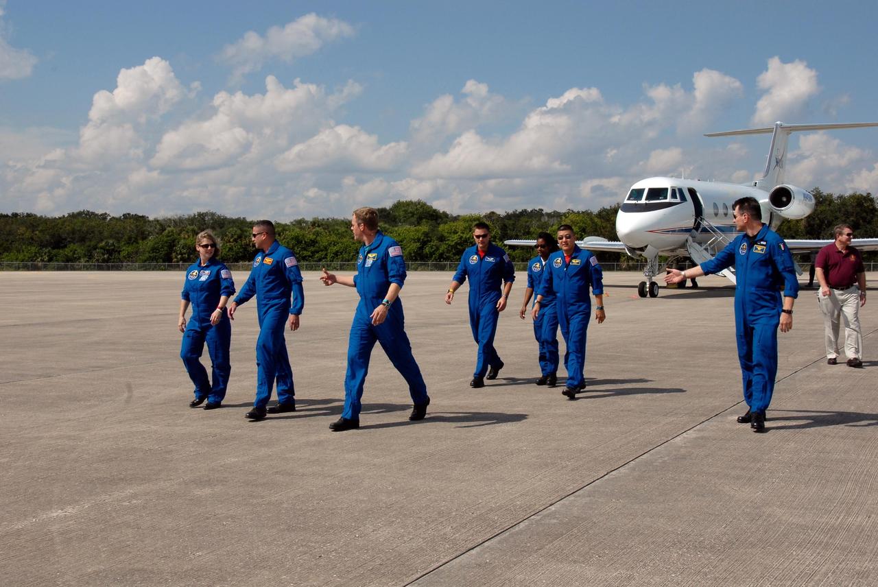 KENNEDY SPACE CENTER, FLA. -- The STS-120 crew walks across the parking area of the Shuttle Landing Facility after arrival at NASA's Kennedy Space Center. From left are Commander Pamela Melroy, Pilot George Zamka and Mission Specialists Scott Parazynski, Doug Wheelock, Stephanie Wilson, Daniel Tani and Paolo Nespoli, who represents the European Space Agency. Tani will be remaining on the International Space Station to join the Expedition 16 crew after the mission is complete. The crew has returned to Kennedy to prepare for launch aboard space shuttle Discovery at 11:38 a.m. EDT on Oct. 23. The mission will be the 23rd shuttle flight to the International Space Station, delivering the Italian-built U.S. Node 2, called Harmony. The 14-day mission includes five spacewalks -- four by shuttle crew members and one by the station’s Expedition 16 crew -- to install Harmony and move the P6 solar arrays to their permanent position and deploy them. Discovery is expected to complete its mission and return home at 4:47 a.m. EST on Nov. 6. Photo credit: NASA/Kim Shiflett