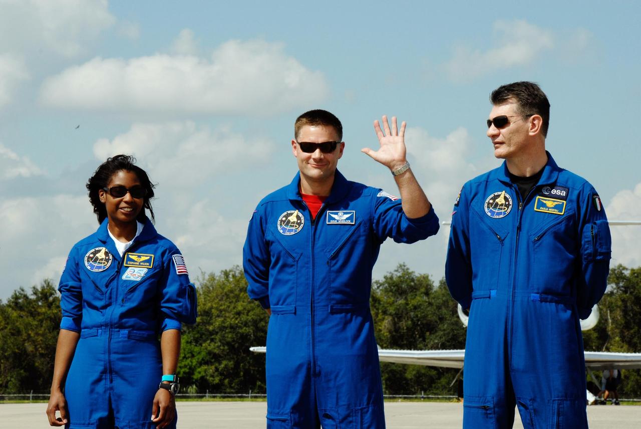 KENNEDY SPACE CENTER, FLA. -- At the Shuttle Landing Facility of NASA's Kennedy Space Center, STS-120 crew members acknowledge the spectators who welcomed the crew's arrival. From left are Mission Specialists Stephanie Wilson, Doug Wheelock and Paolo Nespoli, who represents the European Space Agency. The crew has returned to Kennedy to prepare for launch aboard space shuttle Discovery at 11:38 a.m. EDT on Oct. 23. The mission will be the 23rd shuttle flight to the International Space Station, delivering the Italian-built U.S. Node 2, called Harmony. The 14-day mission includes five spacewalks -- four by shuttle crew members and one by the station’s Expedition 16 crew -- to install Harmony and move the P6 solar arrays to their permanent position and deploy them. Discovery is expected to complete its mission and return home at 4:47 a.m. EST on Nov. 6. Photo credit: NASA/Kim Shiflett