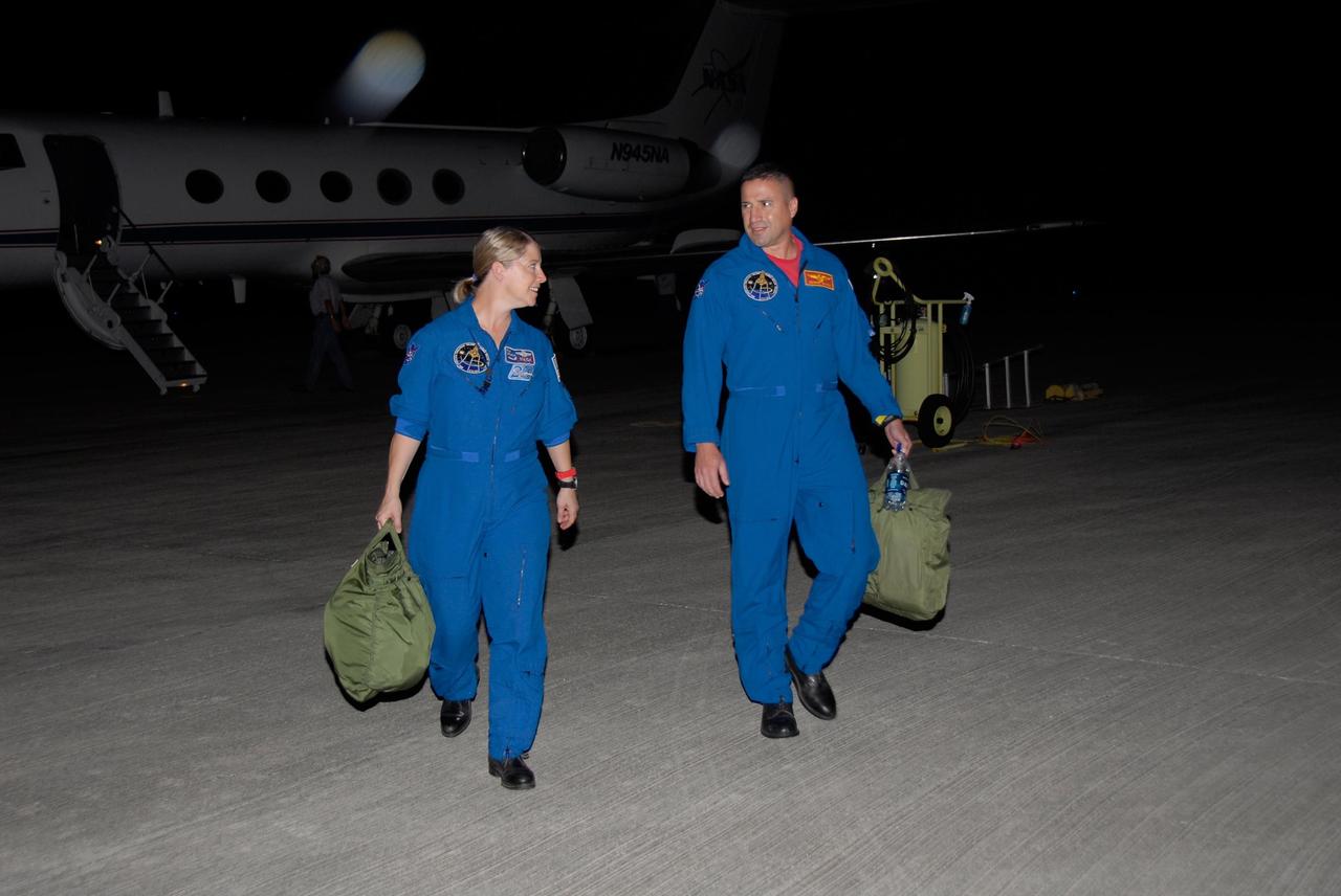 KENNEDY SPACE CENTER, FLA. -- STS-120 Commander Pam Melroy and Pilot George Zamka disembark from the Shuttle Training Aircraft, or STA, behind them on the tarmac at Kennedy Space Center's Shuttle Landing Facility.  They were training for their upcoming space shuttle mission by practicing landings using the STA.  Melroy is the second woman to command a shuttle mission. Also assigned to STS-120 are Mission Specialists Scott Parazynski, Stephanie Wilson, Doug Wheelock, Paolo Nespoli and Daniel Tani. Nespoli represents the European Space Agency. Tani will remain on the International Space Station as an Expedition 16 flight engineer after the STS-120 mission is complete. The mission will be the 23rd shuttle flight to the International Space Station, delivering the Italian-built U.S. Node 2, called Harmony. The crew arrived at Kennedy on Oct. 19 to prepare for launch aboard space shuttle Discovery at 11:38 a.m. EDT Oct. 23. The 14-day mission includes five spacewalks -- four by shuttle crew members and one by the station's Expedition 16 crew -- to install Harmony and move the P6 solar arrays to their permanent position and deploy them. Discovery is expected to complete its mission and return home on Nov. 6.  Photo credit: NASA/Kim Shiflett