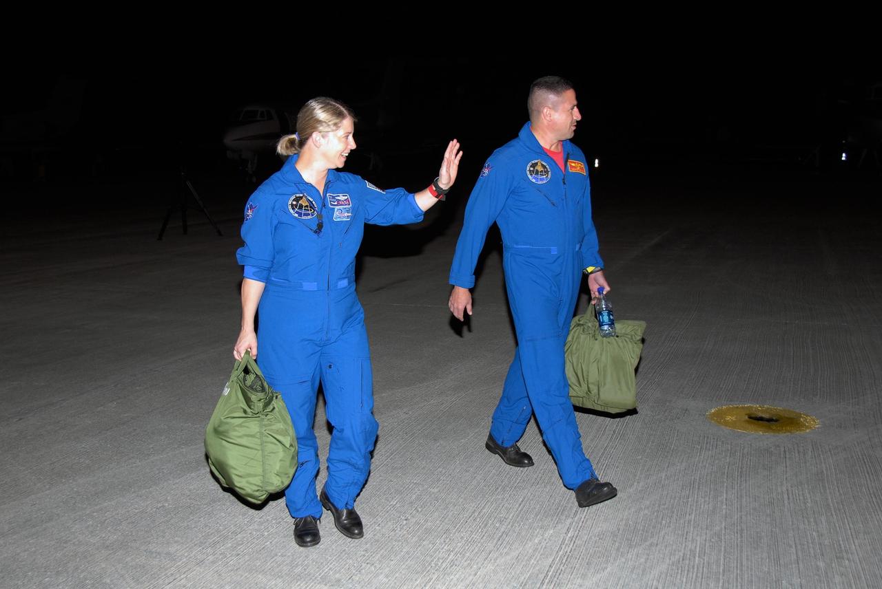 KENNEDY SPACE CENTER, FLA. -- STS-120 Commander Pam Melroy and Pilot George Zamka return to crew quarters after disembarking from a Shuttle Training Aircraft, or STA, on the tarmac at Kennedy Space Center's Shuttle Landing Facility.  They were training for their upcoming space shuttle mission by practicing landings using an STA.  Melroy is the second woman to command a shuttle mission. Also assigned to STS-120 are Mission Specialists Scott Parazynski, Stephanie Wilson, Doug Wheelock, Paolo Nespoli and Daniel Tani. Nespoli represents the European Space Agency. Tani will remain on the International Space Station as an Expedition 16 flight engineer after the STS-120 mission is complete. The mission will be the 23rd shuttle flight to the International Space Station, delivering the Italian-built U.S. Node 2, called Harmony. The crew arrived at Kennedy on Oct. 19 to prepare for launch aboard space shuttle Discovery at 11:38 a.m. EDT Oct. 23. The 14-day mission includes five spacewalks -- four by shuttle crew members and one by the station's Expedition 16 crew -- to install Harmony and move the P6 solar arrays to their permanent position and deploy them. Discovery is expected to complete its mission and return home on Nov. 6.  Photo credit: NASA/Kim Shiflett