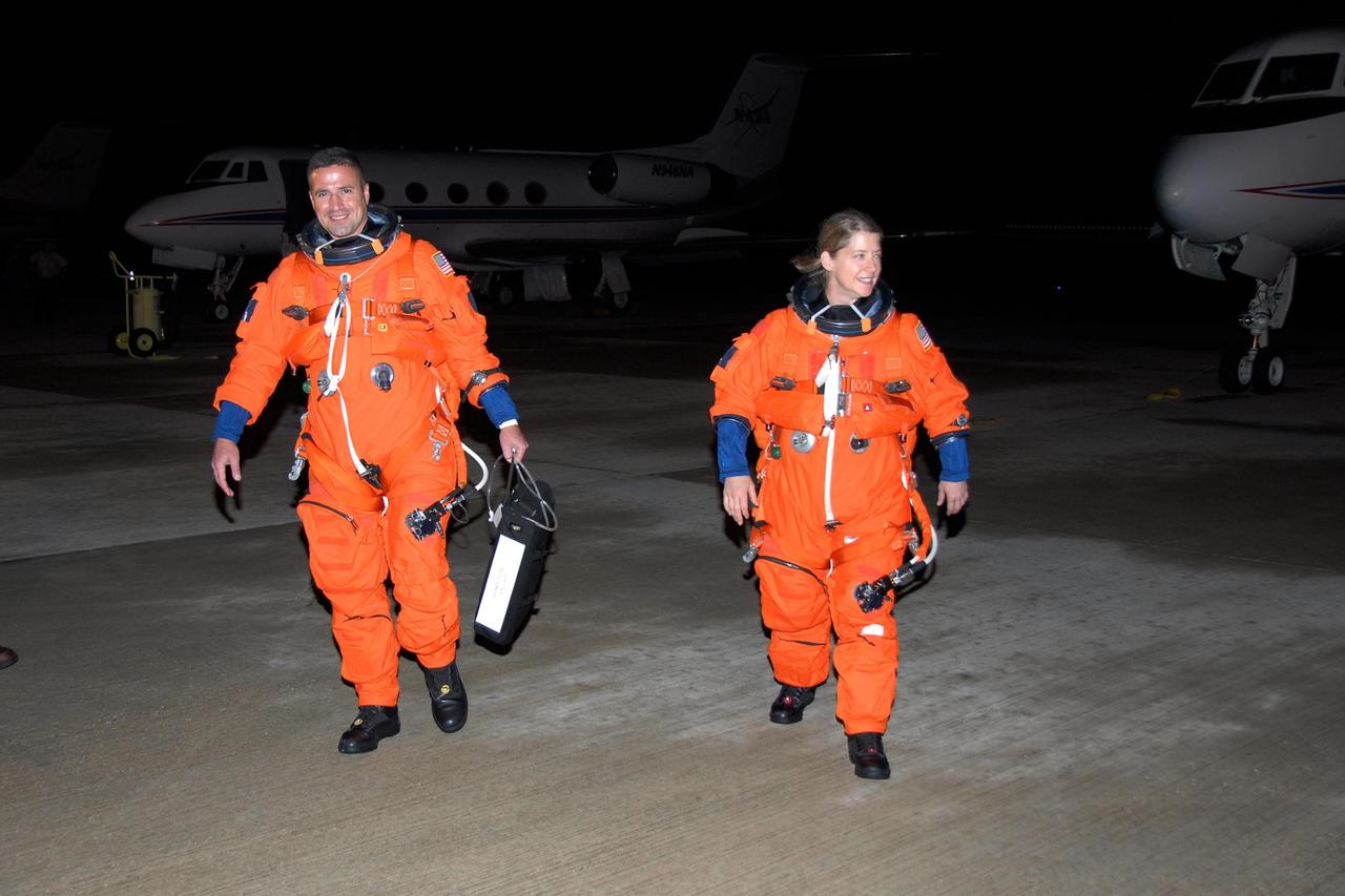 KENNEDY SPACE CENTER, FLA. -- STS-120 Commander Pam Melroy and Pilot George Zamka return to crew quarters after disembarking from the Shuttle Training Aircraft, or STAs, behind them on the tarmac at NASA Kennedy Space Center's Shuttle Landing Facility.  They were training for their upcoming space shuttle mission by practicing landings in the STAs.  Melroy is the second woman to command a shuttle mission. Also assigned to STS-120 are Mission Specialists Scott Parazynski, Stephanie Wilson, Doug Wheelock, Paolo Nespoli and Daniel Tani. Nespoli represents the European Space Agency. Tani will remain on the International Space Station as an Expedition 16 flight engineer after the STS-120 mission is complete. The mission will be the 23rd shuttle flight to the International Space Station, delivering the Italian-built U.S. Node 2, called Harmony. The crew arrived at Kennedy on Oct. 19 to prepare for launch aboard space shuttle Discovery at 11:38 a.m. EDT Oct. 23. The 14-day mission includes five spacewalks -- four by shuttle crew members and one by the station's Expedition 16 crew -- to install Harmony and move the P6 solar arrays to their permanent position and deploy them. Discovery is scheduled to complete its mission and return home on Nov. 6.  Photo credit: NASA/Kim Shiflett