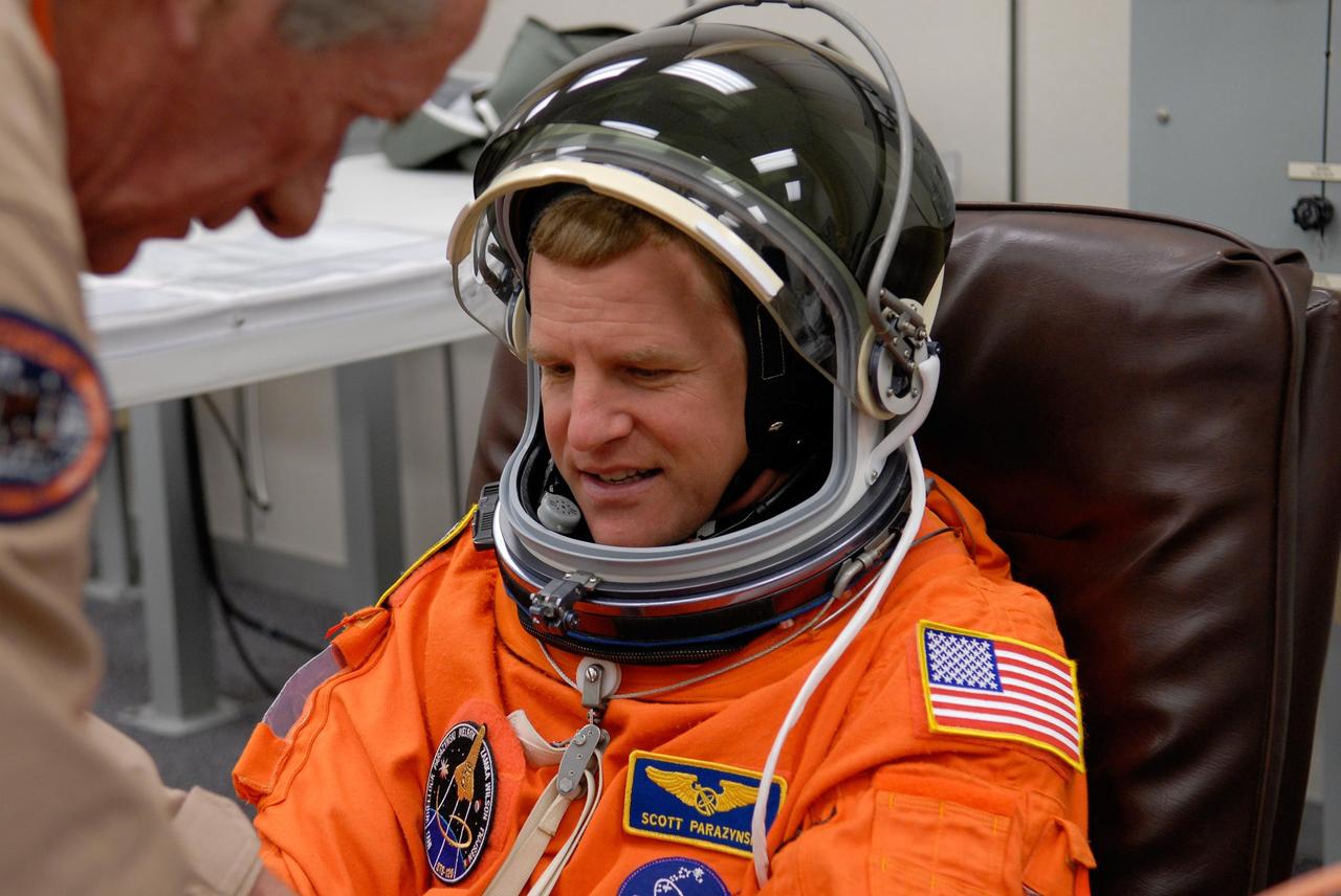 KENNEDY SPACE CENTER, FLA. --  At NASA's Kennedy Space Center, the STS-120 crew don their launch and entry suits before heading to Launch Pad 39A for launch aboard space shuttle Discovery to the International Space Station.  Seen here is Mission Specialist Scott Parazynski, being helped by a suit technician.  Parazynski is making his fifth shuttle flight.  Discovery is scheduled for liftoff at 11:38 a.m. EDT.  The mission will be the 23rd assembly flight to the space station and the 34th flight for Discovery.  Payload on the mission is the Italian-built U.S. Node 2, called Harmony.  During the 14-day mission, the crew will install Harmony and move the P6 solar arrays to their permanent position and deploy them.  Discovery is expected to complete its mission and return home at 4:47 a.m. EST on Nov. 6. Photo credit: NASA/Kim Shiflett