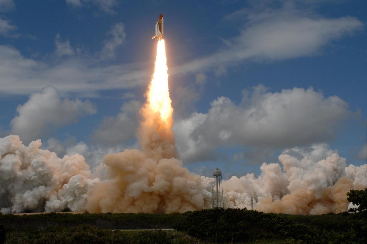 KENNEDY SPACE CENTER, FLA. --  Space shuttle Discovery leaps through the clouds into a blue sky on a column of fire, trailing smoke, as it heads for the International Space Station on mission STS-120.   Billows of clouds and smoke stream across Launch Pad 39A at NASA's Kennedy Space Center.  Liftoff was on time at 11:38:19 a.m. EDT.  Discovery carries the Italian-built U.S. Node 2, called Harmony.  During the 14-day STS-120 mission, the crew will install Harmony and move the P6 solar arrays to their permanent position and deploy them. Discovery is expected to complete its mission and return home at 4:47 a.m. EST on Nov. 6. Photo credit: NASA/Sandra Joseph, Tony Gray & Robert Murray