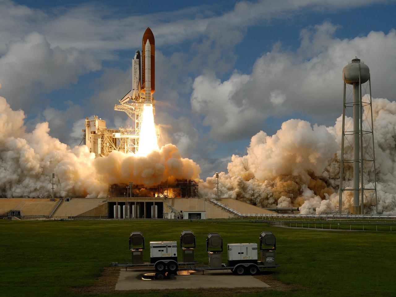 KENNEDY SPACE CENTER, FLA. --  Moments after liftoff on mission STS-120, space shuttle Discovery's solid rocket boosters spew columns of fire, creating clouds of smoke and steam below on Launch Pad 39A at NASA's Kennedy Space Center.  At right is the 300,000-gallon water tower that provides water for the sound suppression system during liftoff, which occurred on time at 11:38:19 a.m. EDT.  Discovery carries the Italian-built U.S. Node 2, called Harmony.  During the 14-day STS-120 mission, the crew will install Harmony and move the P6 solar arrays to their permanent position and deploy them. Discovery is expected to complete its mission and return home at 4:47 a.m. EST on Nov. 6. Photo courtesy of Nikon/Scott Andrews