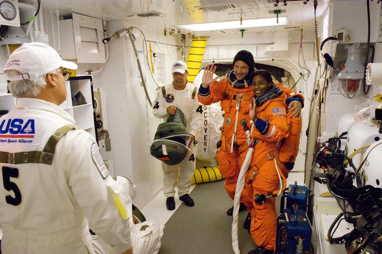 KENNEDY SPACE CENTER, FLA. -- In the White Room on Launch Pad 39A at NASA's Kennedy Space Center, STS-120 Mission Specialists Doug Wheelock and Stephanie Wilson are eager to start the mission, after being  helped by the closeout crew, and enter space shuttle Discovery for liftoff at 11:38 a.m. EDT.  The STS-120 mission will be the 23rd assembly flight to the space station and the 34th flight for Discovery.  Payload on the mission is the Italian-built U.S. Node 2, called Harmony.  During the 14-day mission, the crew will install Harmony and move the P6 solar arrays to their permanent position and deploy them.  Discovery is expected to complete its mission and return home at 4:47 a.m. EST on Nov. 6.   Photo credit: NASA/Scott Haun, Tom Farrar, Rafael Hernandez
