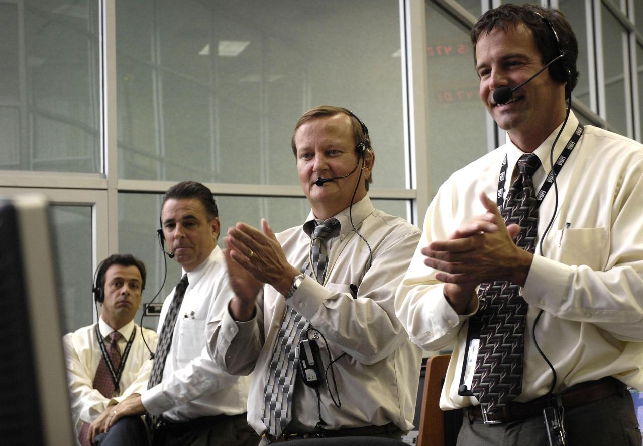 KENNEDY SPACE CENTER, FLA. --  In the firing room at NASA's Kennedy Space Center, Shuttle Launch Director Mike Leinbach (second from right) and Assistant Launch Director Doug Lyons (right) applaud the on-time launch of space shuttle Discovery on mission STS-120.  Liftoff was at 11:38:19 am. EDT.  Discovery carries the Italian-built U.S. Node 2, called Harmony.  During the 14-day STS-120 mission, the crew will install Harmony and move the P6 solar arrays to their permanent position and deploy them. Discovery is expected to complete its mission and return home at 4:47 a.m. EST on Nov. 6. Photo credit: NASA/Bill Ingalls