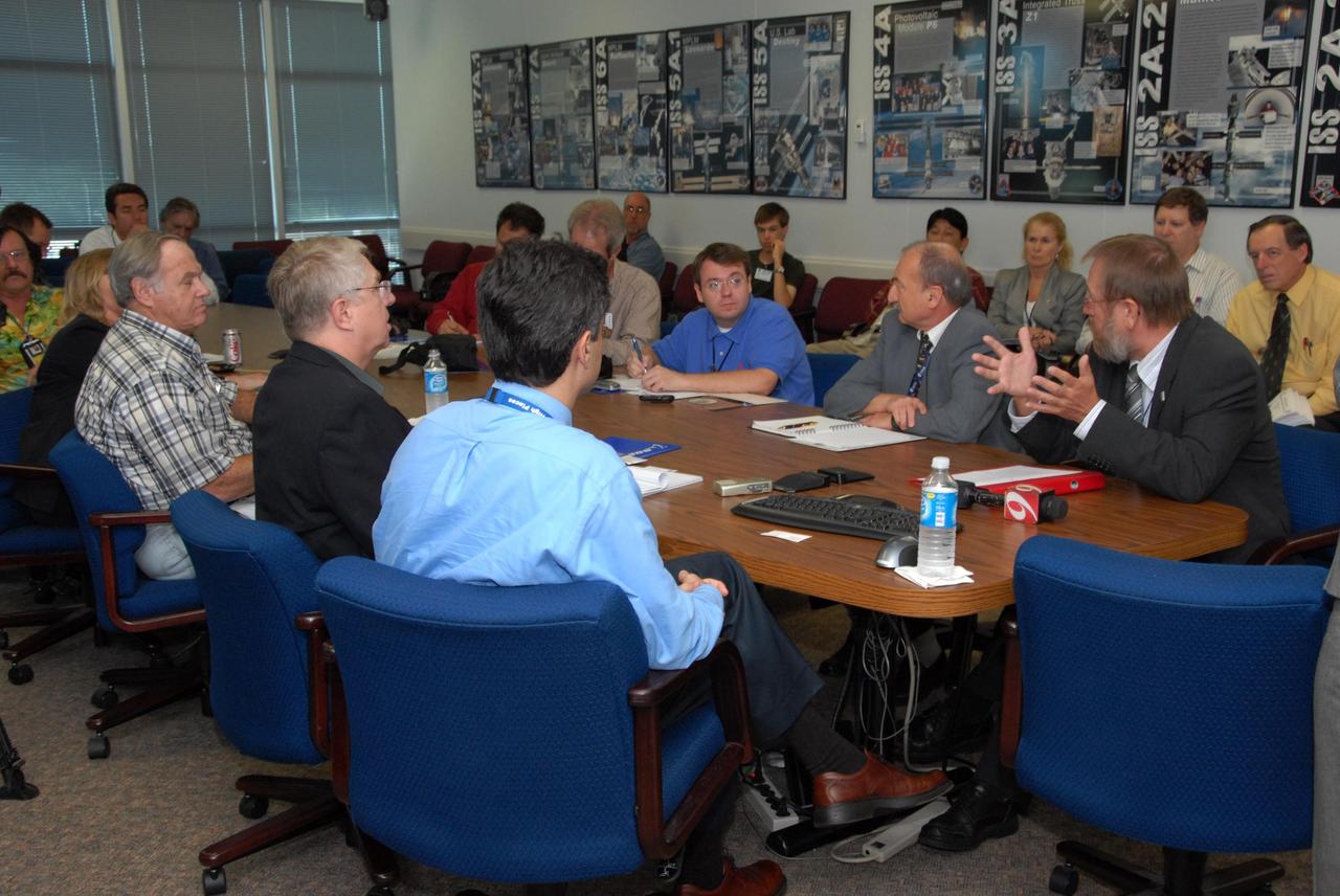 KENNEDY SPACE CENTER, FLA. -- Prior to a showing of the European Space Agency's  Columbus Laboratory module, Gregor Woop (seated at right) talks to the media about the module. Woop is the European Space Agency's product assurance and safety manager.  Columbus is the European Space Agency 's largest single contribution to the International Space Station.  The laboratory module will expand the research facilities of the station, providing crew members and scientists around the world the ability to conduct a variety of life, physical and materials science experiments. The module is approximately 23 feet long and 15 feet wide, allowing it to hold 10 large racks of experiments. Columbus is scheduled to be transferred to Launch Pad 39A in early November, in preparation for its journey to the station. Columbus will fly aboard space shuttle Atlantis on the STS-122 mission, targeted for launch Dec. 6.  Photo credit: NASA/George Shelton