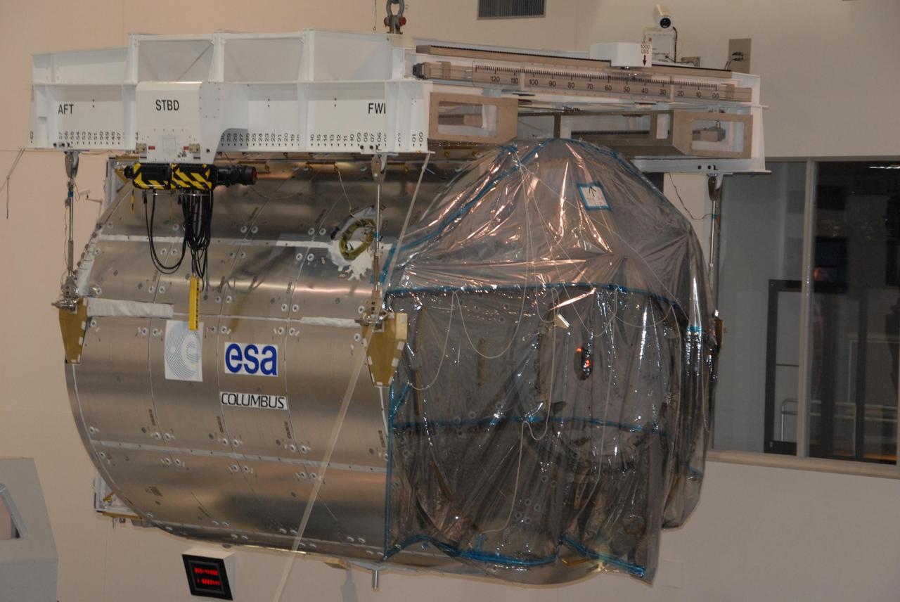 KENNEDY SPACE CENTER, FLA. -- In the Space Station Processing Facility at NASA's Kennedy Space Center, an overhead crane lifts the Columbus Laboratory module from its stand.  The module is being moved to a weigh station before transfer to the payload canister.  The European Space Agency 's largest single contribution to the International Space Station, Columbus will expand the research facilities of the station, providing crew members and scientists around the world the ability to conduct a variety of life, physical and materials science experiments. The module is approximately 23 feet long and 15 feet wide, allowing it to hold 10 large racks of experiments. The module is scheduled to be transferred to Launch Pad 39A in early November, in preparation for its journey to the station. Columbus will fly aboard space shuttle Atlantis on the STS-122 mission, targeted for launch Dec. 6.  Photo credit: NASA/George Shelton
