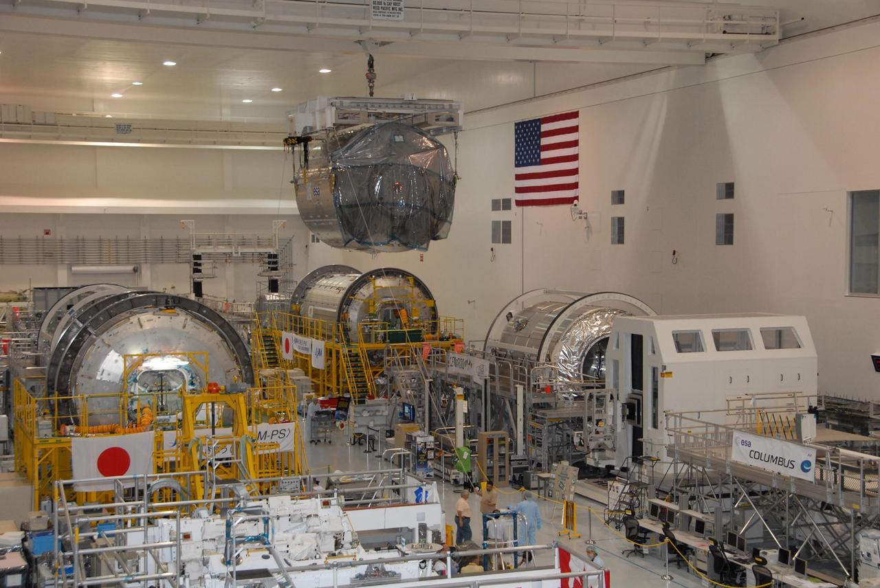 KENNEDY SPACE CENTER, FLA. -- In the Space Station Processing Facility at NASA's Kennedy Space Center, the Columbus Laboratory module moves across the facility to a payload canister.  The canister will transport the module and other payloads to Launch Pad 39A in preparation for its journey to the International Space Station.  The European Space Agency 's largest single contribution to the International Space Station, Columbus will expand the research facilities of the station, providing crew members and scientists around the world the ability to conduct a variety of life, physical and materials science experiments. The module is approximately 23 feet long and 15 feet wide, allowing it to hold 10 large racks of experiments. The module is scheduled to be transferred to Launch Pad 39A in early November, in preparation for its journey to the station. Columbus will fly aboard space shuttle Atlantis on the STS-122 mission, targeted for launch Dec. 6.  Photo credit: NASA/George Shelton