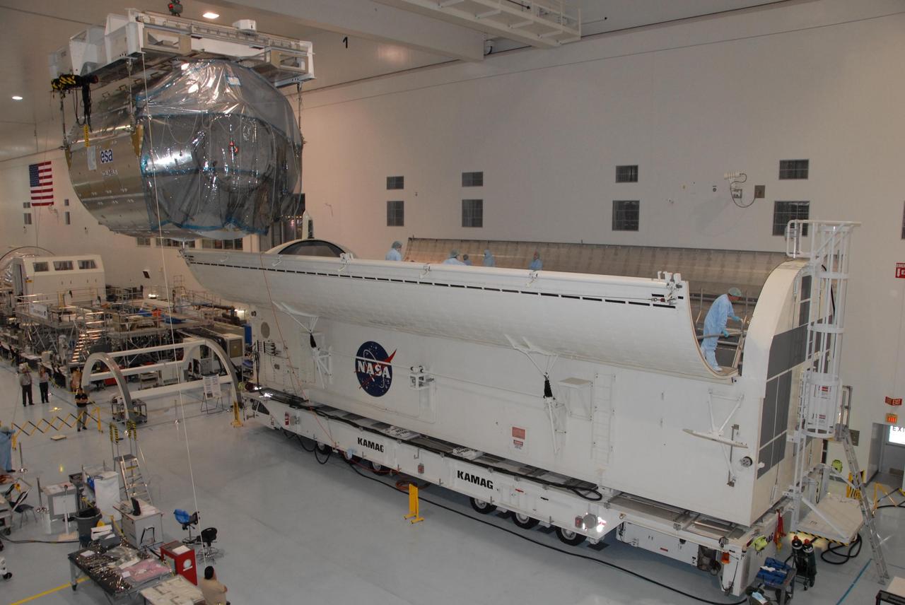 KENNEDY SPACE CENTER, FLA. -- In the Space Station Processing Facility at NASA's Kennedy Space Center, the Columbus Laboratory module moves toward the waiting payload canister at right.  The canister will transport the module and other payloads to Launch Pad 39A in preparation for its journey to the International Space Station.  The European Space Agency 's largest single contribution to the International Space Station, Columbus will expand the research facilities of the station, providing crew members and scientists around the world the ability to conduct a variety of life, physical and materials science experiments. The module is approximately 23 feet long and 15 feet wide, allowing it to hold 10 large racks of experiments. The module is scheduled to be transferred to Launch Pad 39A in early November, in preparation for its journey to the station. Columbus will fly aboard space shuttle Atlantis on the STS-122 mission, targeted for launch Dec. 6.  Photo credit: NASA/George Shelton