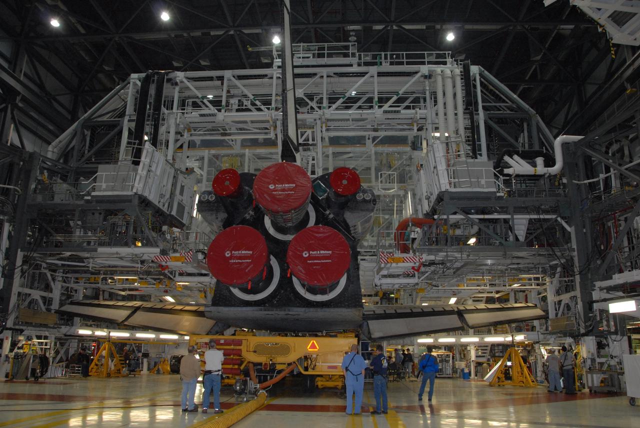 KENNEDY SPACE CENTER, FLA. -- In Orbiter Processing Facility bay 1, workers prepare to roll space shuttle Atlantis to the Vehicle Assembly Building. Rollover from its processing bay began at 7:05 a.m. EDT. Atlantis arrived in the VAB's transfer aisle at 8:03 a.m. In the VAB, the shuttle will be lifted and mated with the external tank and solid rocket boosters designated for mission STS-122, already secured atop a mobile launcher platform.  On this mission, Atlantis will deliver the Columbus module to the International Space Station.  The European Space Agency's largest contribution to the station, Columbus is a multifunctional, pressurized laboratory that will be permanently attached to U.S. Node 2, called Harmony. The module is approximately 23 feet long and 15 feet wide, allowing it to hold 10 large racks of experiments.  The laboratory will expand the research facilities aboard the station, providing crew members and scientists from around the world the ability to conduct a variety of experiments in the physical, materials and life sciences.  Mission STS-122 is targeted for launch on Dec. 6.  Photo credit: NASA/George Shelton