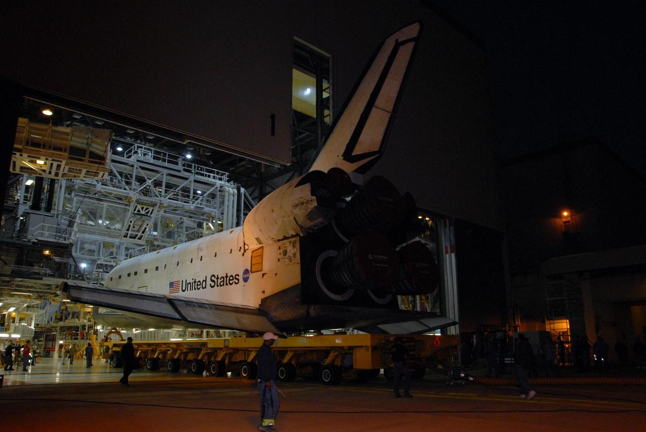 KENNEDY SPACE CENTER, FLA. -- Space shuttle Atlantis rolls out of Orbiter Processing Facility bay 1 on a transporter just before sunrise for the short trip to the Vehicle Assembly Building.  Rollover from its processing bay began at 7:05 a.m. EDT. Atlantis arrived in the VAB's transfer aisle at 8:03 a.m. In the VAB, the shuttle will be lifted and mated with the external tank and solid rocket boosters designated for mission STS-122, already secured atop a mobile launcher platform.  On this mission, Atlantis will deliver the Columbus module to the International Space Station.  The European Space Agency's largest contribution to the station, Columbus is a multifunctional, pressurized laboratory that will be permanently attached to U.S. Node 2, called Harmony. The module is approximately 23 feet long and 15 feet wide, allowing it to hold 10 large racks of experiments.  The laboratory will expand the research facilities aboard the station, providing crew members and scientists from around the world the ability to conduct a variety of experiments in the physical, materials and life sciences.  Mission STS-122 is targeted for launch on Dec. 6.  Photo credit: NASA/George Shelton