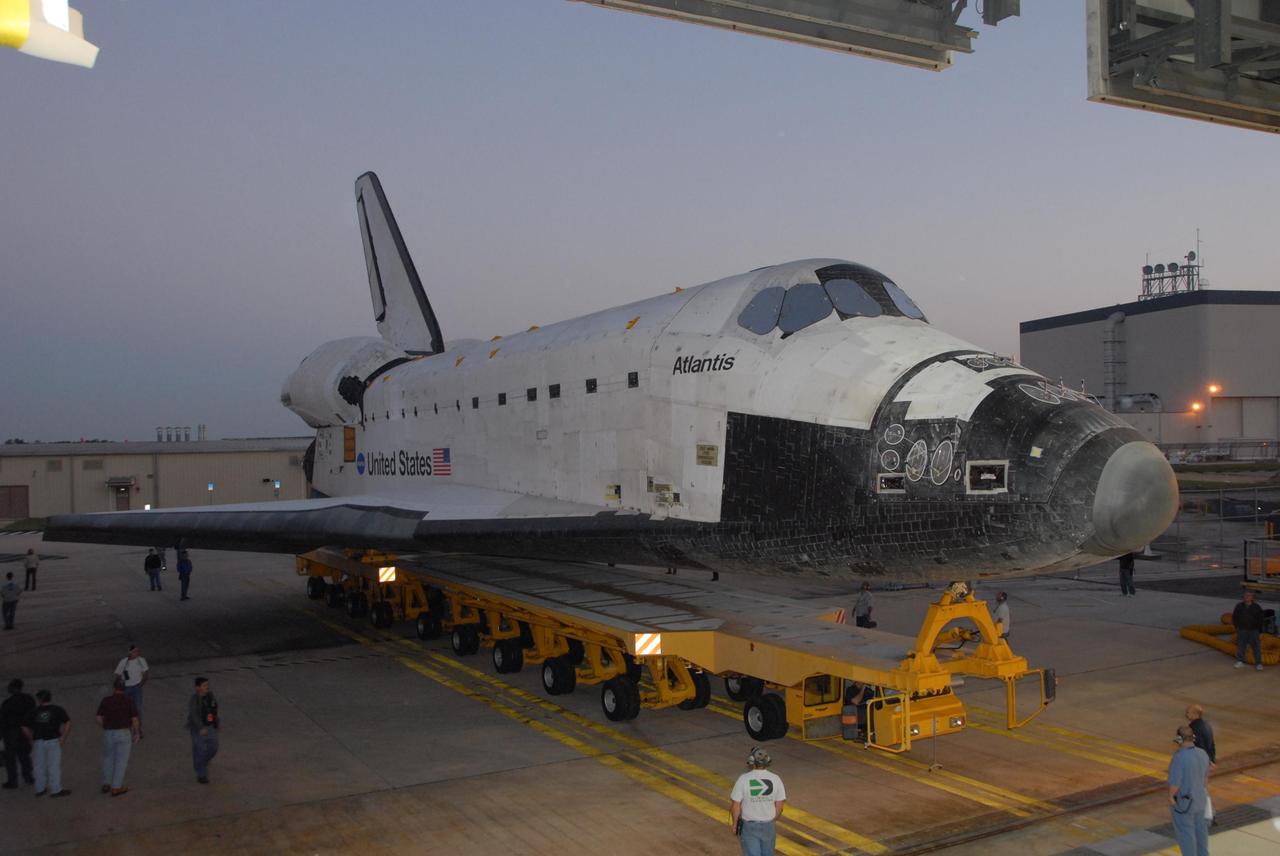 KENNEDY SPACE CENTER, FLA. -- Space shuttle Atlantis rolls out of Orbiter Processing Facility bay 1 on a transporter as the sun rises.  The orbiter is headed for the Vehicle Assembly Building.  Rollover from its processing bay began at 7:05 a.m. EDT. Atlantis arrived in the VAB's transfer aisle at 8:03 a.m. In the VAB, the shuttle will be lifted and mated with the external tank and solid rocket boosters designated for mission STS-122, already secured atop a mobile launcher platform.  On this mission, Atlantis will deliver the Columbus module to the International Space Station.  The European Space Agency's largest contribution to the station, Columbus is a multifunctional, pressurized laboratory that will be permanently attached to U.S. Node 2, called Harmony. The module is approximately 23 feet long and 15 feet wide, allowing it to hold 10 large racks of experiments.  The laboratory will expand the research facilities aboard the station, providing crew members and scientists from around the world the ability to conduct a variety of experiments in the physical, materials and life sciences.  Mission STS-122 is targeted for launch on Dec. 6.  Photo credit: NASA/George Shelton