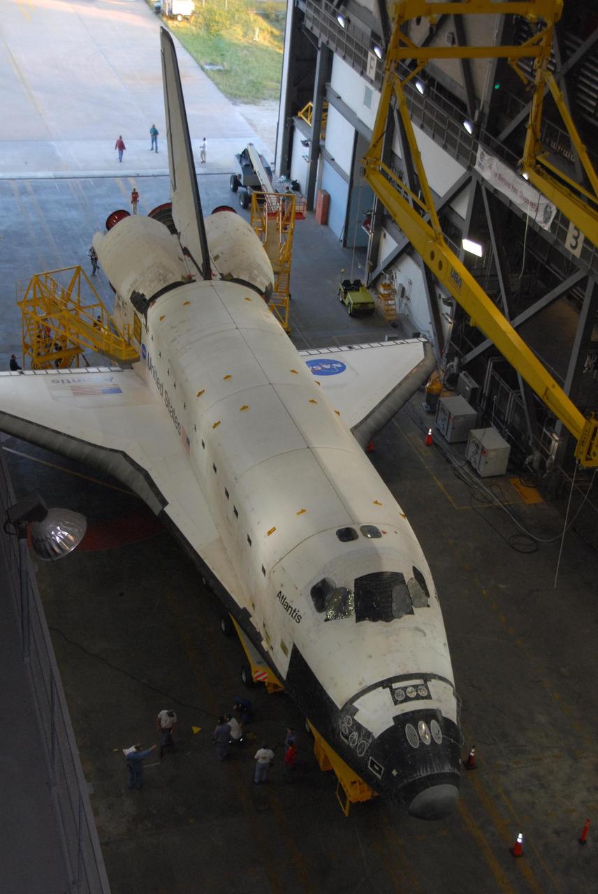 KENNEDY SPACE CENTER, FLA. -- Workers position platforms around space shuttle Atlantis in the transfer aisle of the Vehicle Assembly Building after its move from Orbiter Processing Facility bay 1.  Rollover from its processing bay began at 7:05 a.m. EDT. Atlantis arrived in the VAB's transfer aisle at 8:03 a.m. In the VAB, the shuttle will be lifted and mated with the external tank and solid rocket boosters designated for mission STS-122, already secured atop a mobile launcher platform.  On this mission, Atlantis will deliver the Columbus module to the International Space Station.  The European Space Agency's largest contribution to the station, Columbus is a multifunctional, pressurized laboratory that will be permanently attached to U.S. Node 2, called Harmony. The module is approximately 23 feet long and 15 feet wide, allowing it to hold 10 large racks of experiments.  The laboratory will expand the research facilities aboard the station, providing crew members and scientists from around the world the ability to conduct a variety of experiments in the physical, materials and life sciences.  Mission STS-122 is targeted for launch on Dec. 6.  Photo credit: NASA/George Shelton