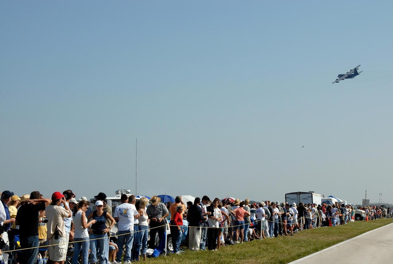 KENNEDY SPACE CENTER, FLA. --  Crowds fill the areas along NASA Causeway at NASA's Kennedy Space Center to watch the World Space Expo aerial salute.  Seen in flight is the plane used to refuel rescue helicopters in mid-air. Aircraft joining in the expo salute include the U.S. Air Force Thunderbirds Demonstration Squadron, the U.S. Navy F-18 Super Hornets, U.S. Air Force F-22 Raptor,  U.S. Air Force F-15 Eagle, P-51 Mustang Heritage Flight, the U.S. Air Force 920th Rescue Wing, which was responsible for Mercury and Gemini capsule recovery, and the U.S. Army Golden Knights precision skydivers. The World Space Expo held Nov. 1-4 was an event commemorating humanity's first 50 years in space while looking forward to returning people to the moon and exploring beyond. The expo showcased various panels, presentations and educational programs. It also was a part of NASA's 50th anniversary celebrations, highlighting the 45th Anniversary of the Mercury Program celebration featuring original NASA astronauts John Glenn and Scott Carpenter and the Pioneering Women of Aerospace forum featuring Eileen Collins and other prominent female space veterans. The agency was founded Oct. 1, 1958.   Photo credit: NASA/Kim Shiflett