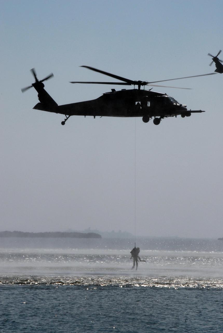 KENNEDY SPACE CENTER, FLA. --  Near the NASA Causeway at NASA's Kennedy Space Center, part of the U.S. Air Force 920th Rescue Wing puts on a rescue demonstration during the World Space Expo aerial salute.  This unit was responsible for Mercury and Gemini capsule recovery.  Other aircraft joining in the expo salute include the U.S. Air Force Thunderbirds Demonstration Squadron, the U.S. Navy F-18 Super Hornets, U.S. Air Force F-22 Raptor,  U.S. Air Force F-15 Eagle, P-51 Mustang Heritage Flight, and the U.S. Army Golden Knights demonstrating precision skydiving. The World Space Expo held Nov. 1-4 was an event commemorating humanity's first 50 years in space while looking forward to returning people to the moon and exploring beyond. The expo showcased various panels, presentations and educational programs. It also was a part of NASA's 50th anniversary celebrations, highlighting the 45th Anniversary of the Mercury Program celebration featuring original NASA astronauts John Glenn and Scott Carpenter and the Pioneering Women of Aerospace forum featuring Eileen Collins and other prominent female space veterans. The agency was founded Oct. 1, 1958.   Photo credit: NASA/Kim Shiflett