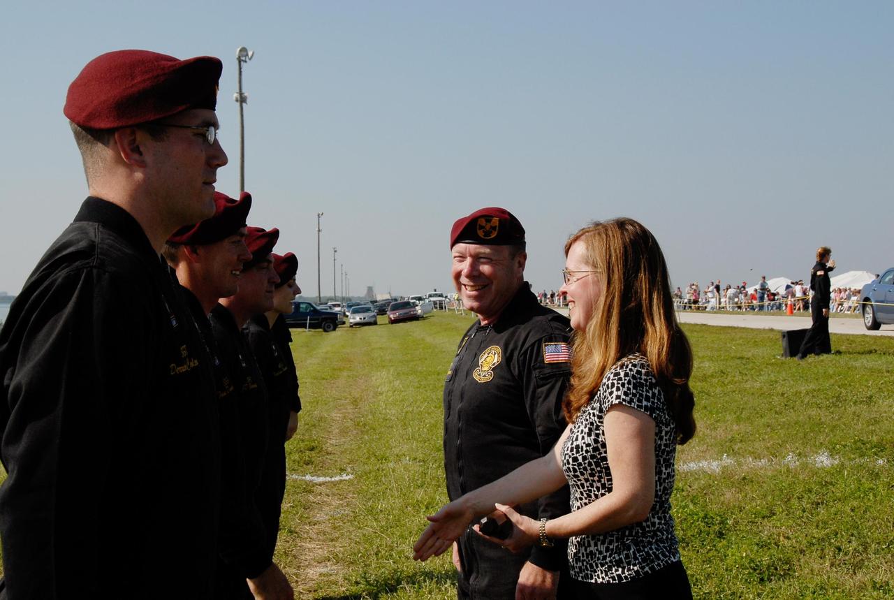 KENNEDY SPACE CENTER, FLA. --  At NASA's Kennedy Space Center, External Relations Director Lisa Malone greets members of the U.S. Army Golden Knights, a precision skydiving team who were part of the World Space Expo aerial salute.  Other aircraft joining in the expo salute include the U.S. Air Force Thunderbirds Demonstration Squadron, the U.S. Navy F-18 Super Hornets, U.S. Air Force F-22 Raptor,  U.S. Air Force F-15 Eagle, P-51 Mustang Heritage Flight, and the U.S. Air Force 920th Rescue Wing, which was responsible for Mercury and Gemini capsule recovery. The World Space Expo held Nov. 1-4 was an event commemorating humanity's first 50 years in space while looking forward to returning people to the moon and exploring beyond. The expo showcased various panels, presentations and educational programs. It also was a part of NASA's 50th anniversary celebrations, highlighting the 45th Anniversary of the Mercury Program celebration featuring original NASA astronauts John Glenn and Scott Carpenter and the Pioneering Women of Aerospace forum featuring Eileen Collins and other prominent female space veterans. The agency was founded Oct. 1, 1958.   Photo credit: NASA/Kim Shiflett
