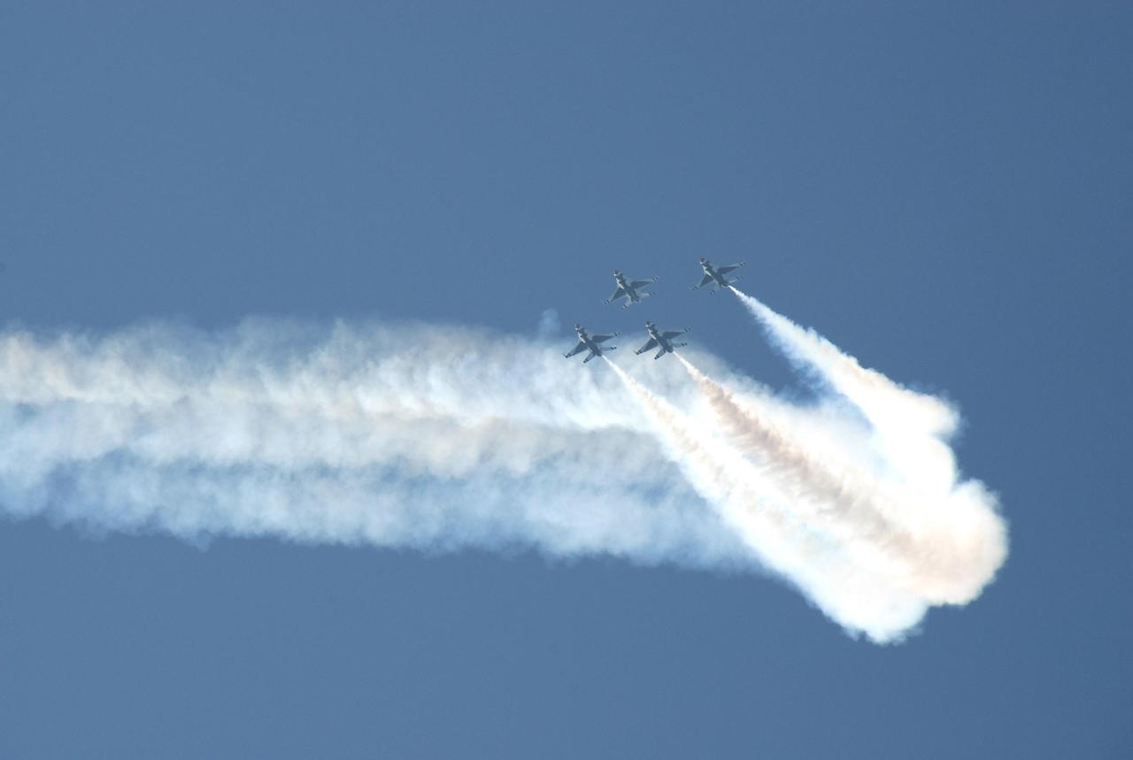 KENNEDY SPACE CENTER, FLA. --  The U.S. Air Force Thunderbirds Demonstration Squadron flies in formation over NASA's Kennedy Space Center as part of the World Space Expo aerial salute.  Other aircraft joining in the expo salute include the U.S. Navy F-18 Super Hornets, U.S. Air Force F-22 Raptor,  U.S. Air Force F-15 Eagle, P-51 Mustang Heritage Flight, and the U.S. Air Force 920th Rescue Wing, which was responsible for Mercury and Gemini capsule recovery, and the U.S. Army Golden Knights precision skydiving team. The World Space Expo held Nov. 1-4 was an event commemorating humanity's first 50 years in space while looking forward to returning people to the moon and exploring beyond. The expo showcased various panels, presentations and educational programs. It also was a part of NASA's 50th anniversary celebrations, highlighting the 45th Anniversary of the Mercury Program celebration featuring original NASA astronauts John Glenn and Scott Carpenter and the Pioneering Women of Aerospace forum featuring Eileen Collins and other prominent female space veterans. The agency was founded Oct. 1, 1958.   Photo credit: NASA/Kim Shiflett