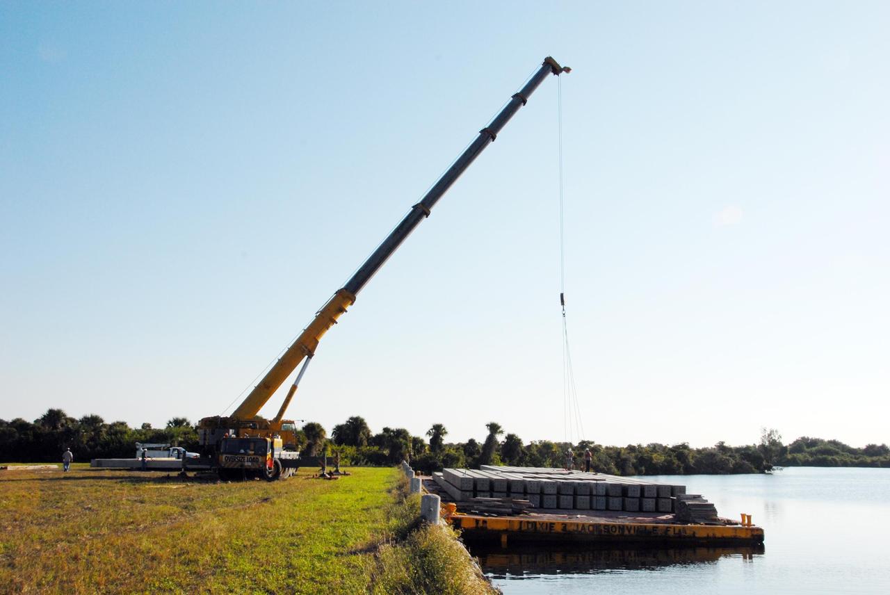 KENNEDY SPACE CENTER, FLA. -- In the Launch Complex 39 Area turn basin at NASA's Kennedy Space Center, the crane crawler is being used to lift pilings from a barge. The pilings will be used to help construct new lightning towers on Launch Pad 39B for the Constellation Program and Ares/Orion launches. Pad B will be the site of the first Ares vehicle launch, including Ares I-X which is scheduled for April 2009. Photo credit: NASA/George Shelton