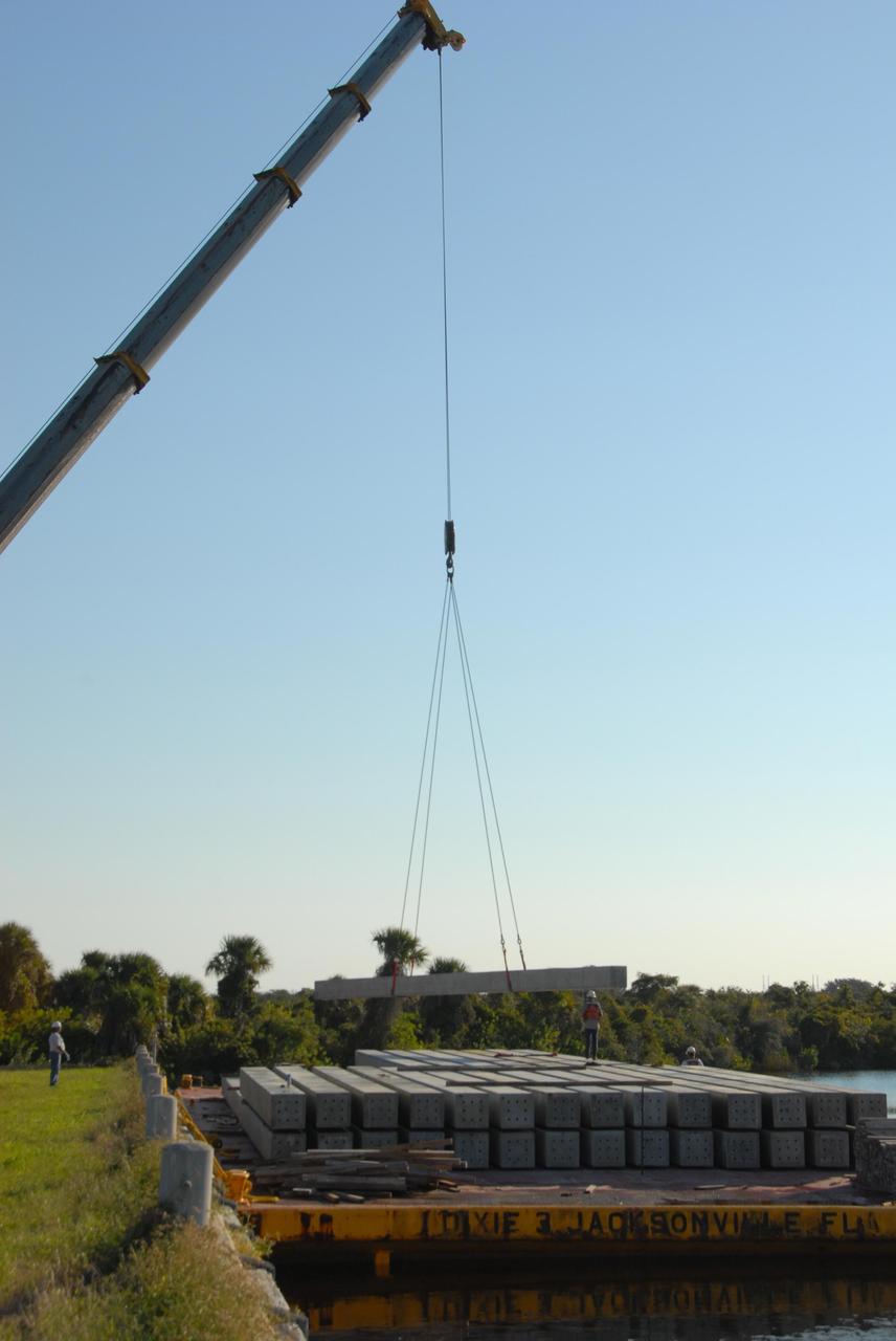 KENNEDY SPACE CENTER, FLA. -- In the Launch Complex 39 Area turn basin at NASA's Kennedy Space Center, the crane crawler begins lifting pilings from the barge. The pilings will be used to help construct new lightning towers on Launch Pad 39B for the Constellation Program and Ares/Orion launches. Pad B will be the site of the first Ares vehicle launch, including Ares I-X which is scheduled for April 2009. Photo credit: NASA/George Shelton