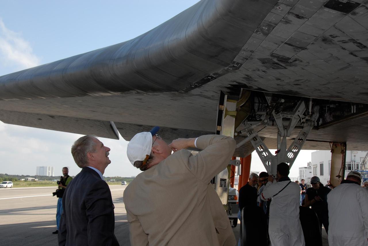 KENNEDY SPACE CENTER, FLA. --  Associate Administrator for NASA Space Operations William Gerstenmaier and Shuttle Program Manager Wayne Hale examine the thermal protection system on the wing of space shuttle Discovery after its landing at NASA's Kennedy Space Center. Discovery completed the 15-day mission STS-120, with an on-time landing at 1:01:16 p.m.  Wheel stop was at 1:02:07 p.m.  Mission elapsed time was 15 days, 2 hours, 24 minutes and 2 seconds.  Mission STS-120 continued the construction of the station with the installation of the Harmony Node 2 module and the relocation of the P6 truss. Photo credit: NASA//Kim Shiflett