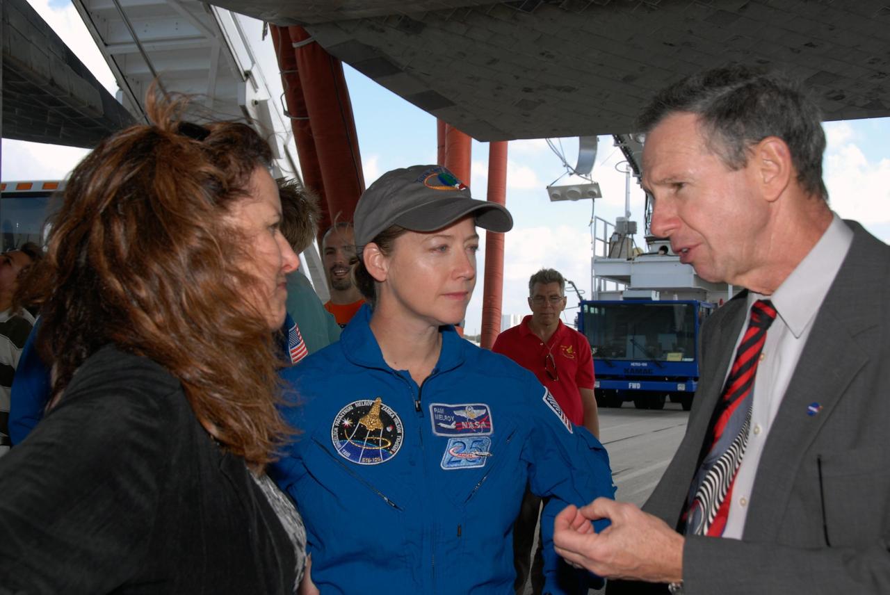 KENNEDY SPACE CENTER, FLA. --   Standing underneath space shuttle Discovery on the Shuttle Landing Facility at NASA's Kennedy Space Center, NASA Administrator Mike Griffin, right, talks with STS-120 Commander Pamela Melroy, center, after the landing of the vehicle.  At left is Rebecca Griffin, wife of the administrator.  The Discovery crew completed the 15-day mission STS-120, with an on-time landing at 1:01:16 p.m.  Wheel stop was at 1:02:07 p.m.  Mission elapsed time was 15 days, 2 hours, 24 minutes and 2 seconds.  Mission STS-120 continued the construction of the station with the installation of the Harmony Node 2 module and the relocation of the P6 truss. Photo credit: NASA/Kim Shiflett